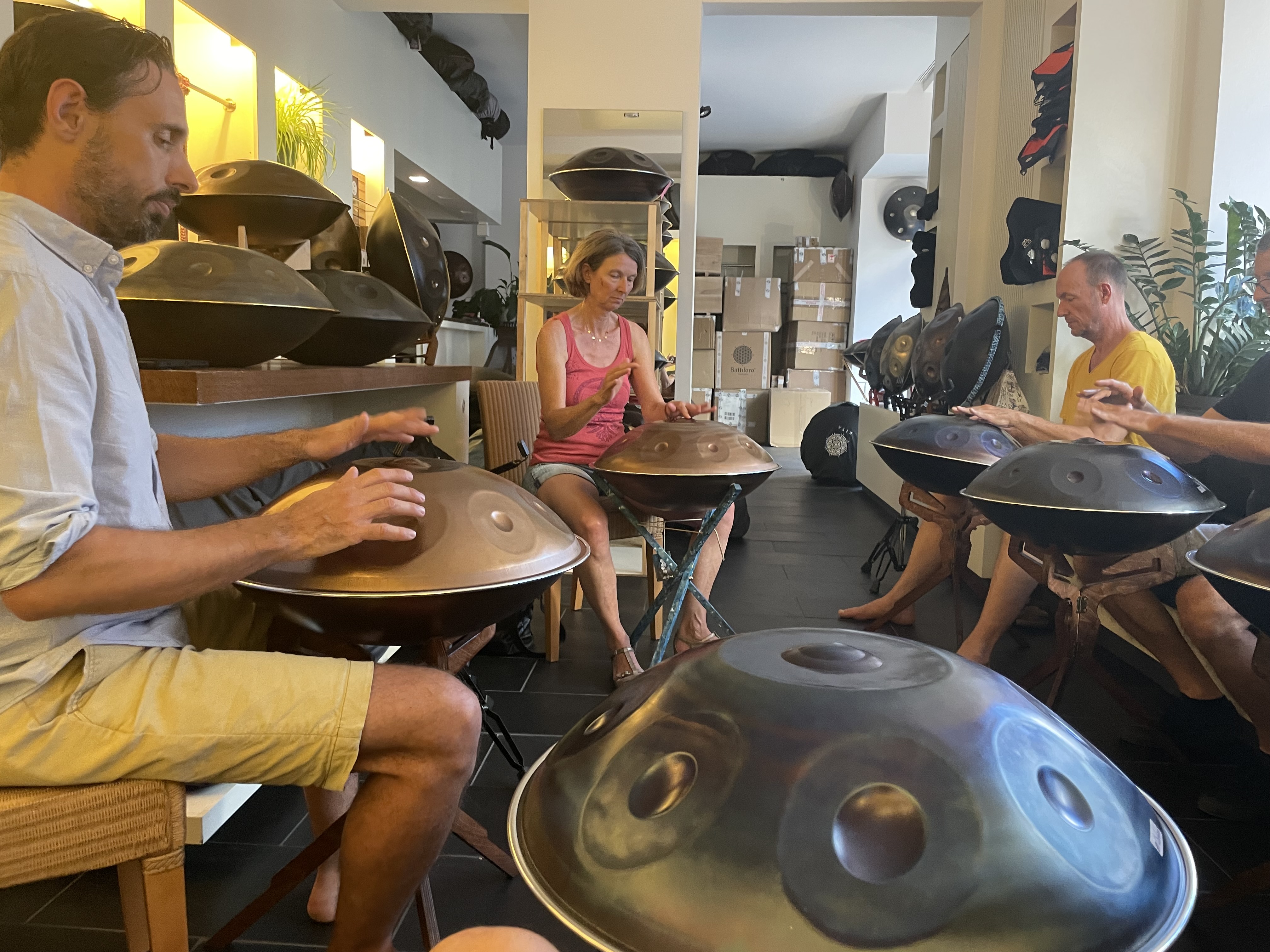 Menschen spielen Handpan in einem hellen Raum.
