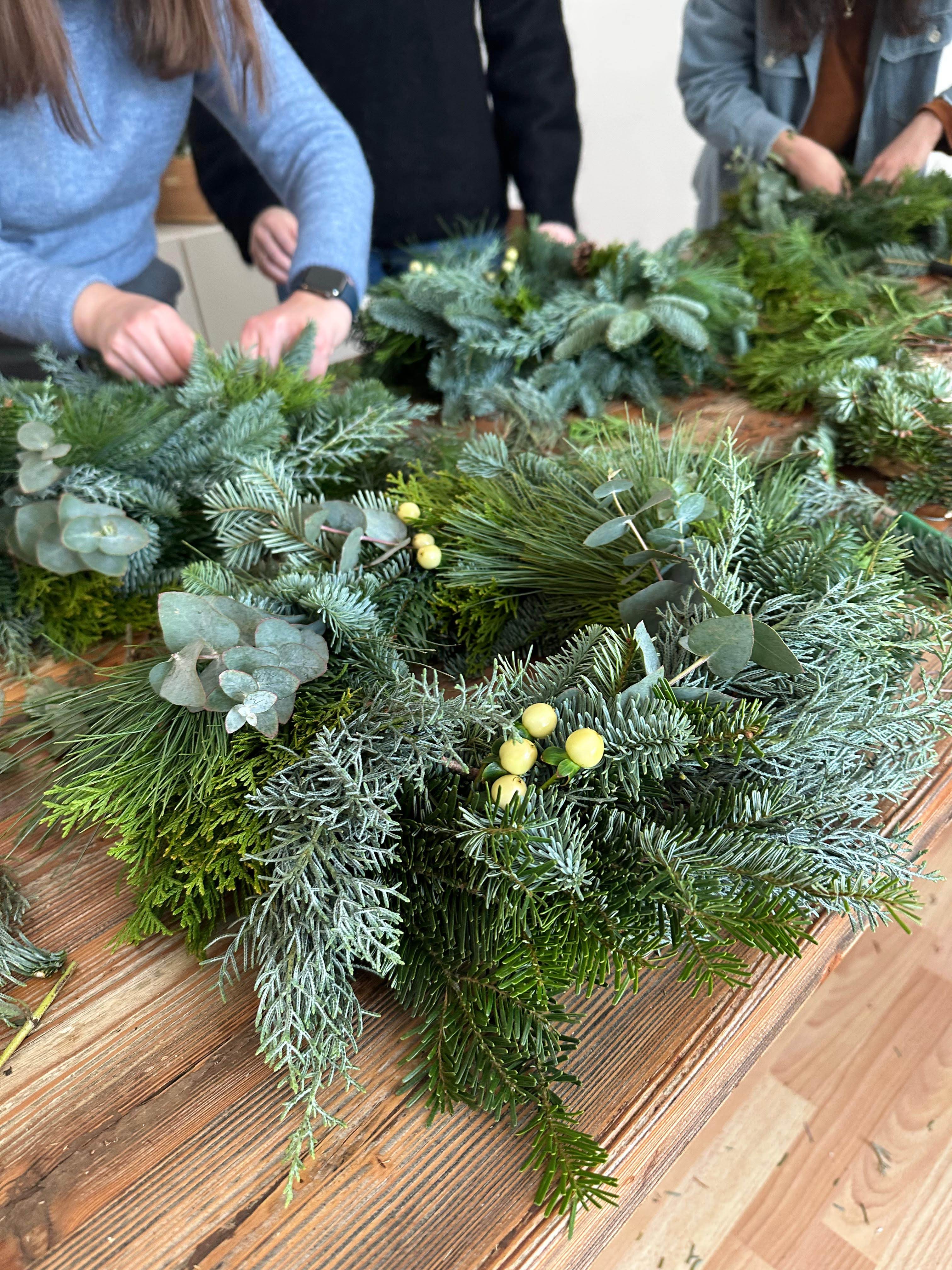 Green wreath with leaves and yellow berries.