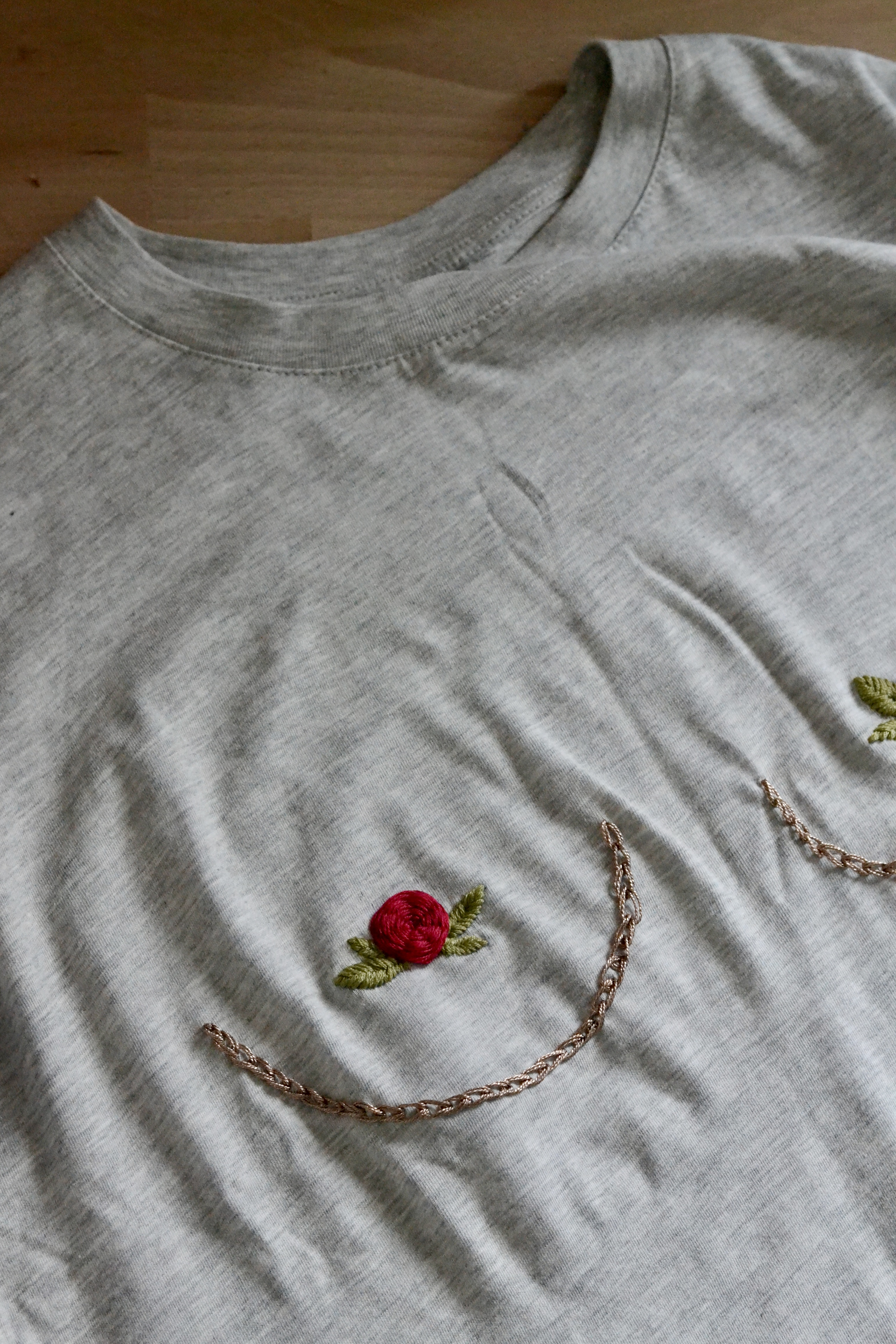 Red rose embroidery on gray fabric.