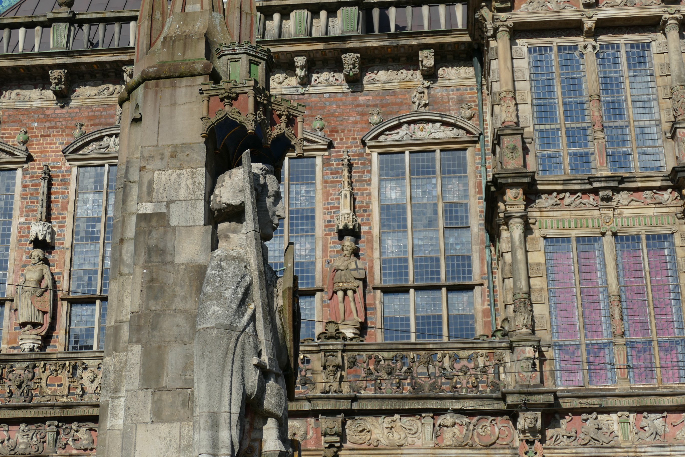Ritterstatue vor historischer Gebäudefassade.