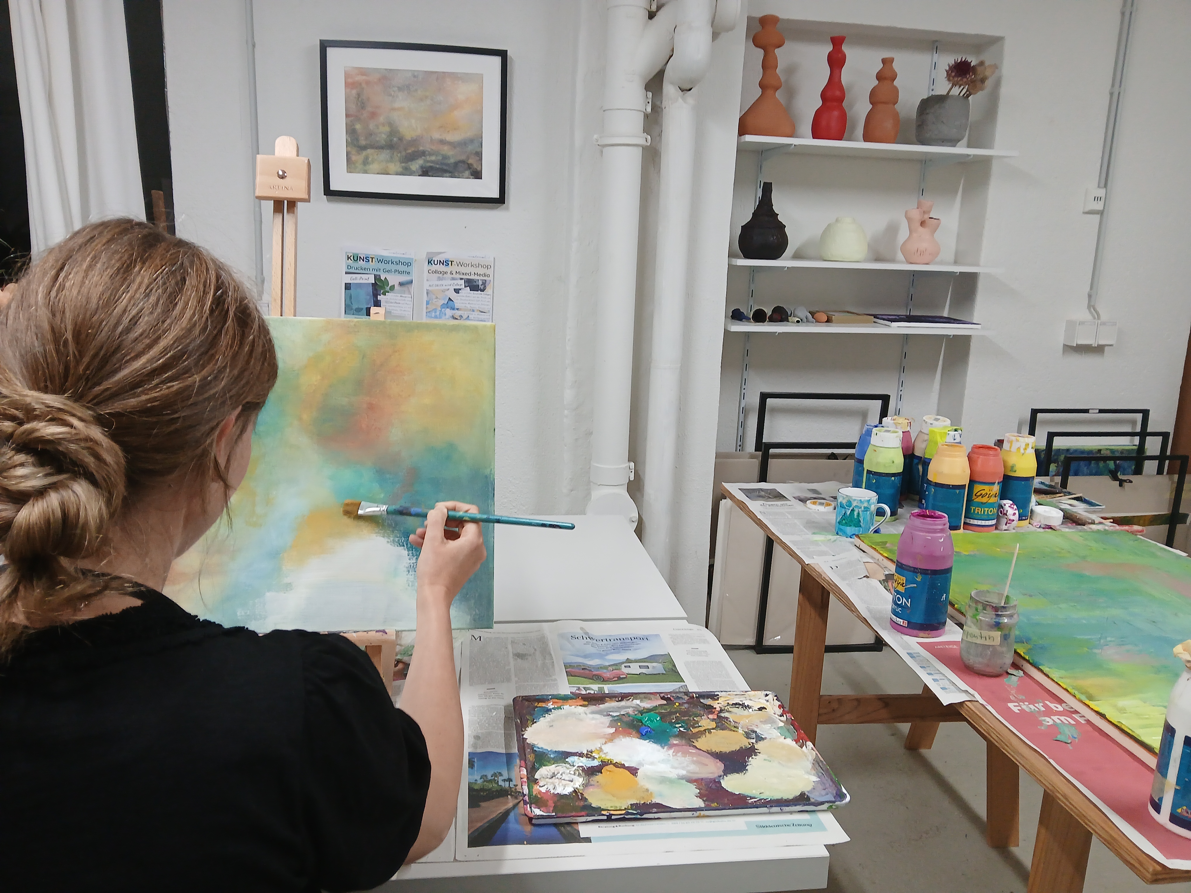 Frau malt auf Leinwand im Kunststudio.