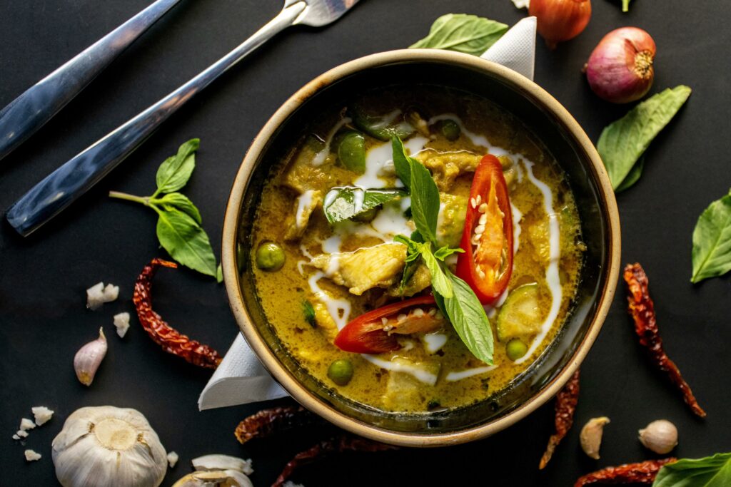 Thailändisches Curry mit Gemüse und Kräutern auf Teller.