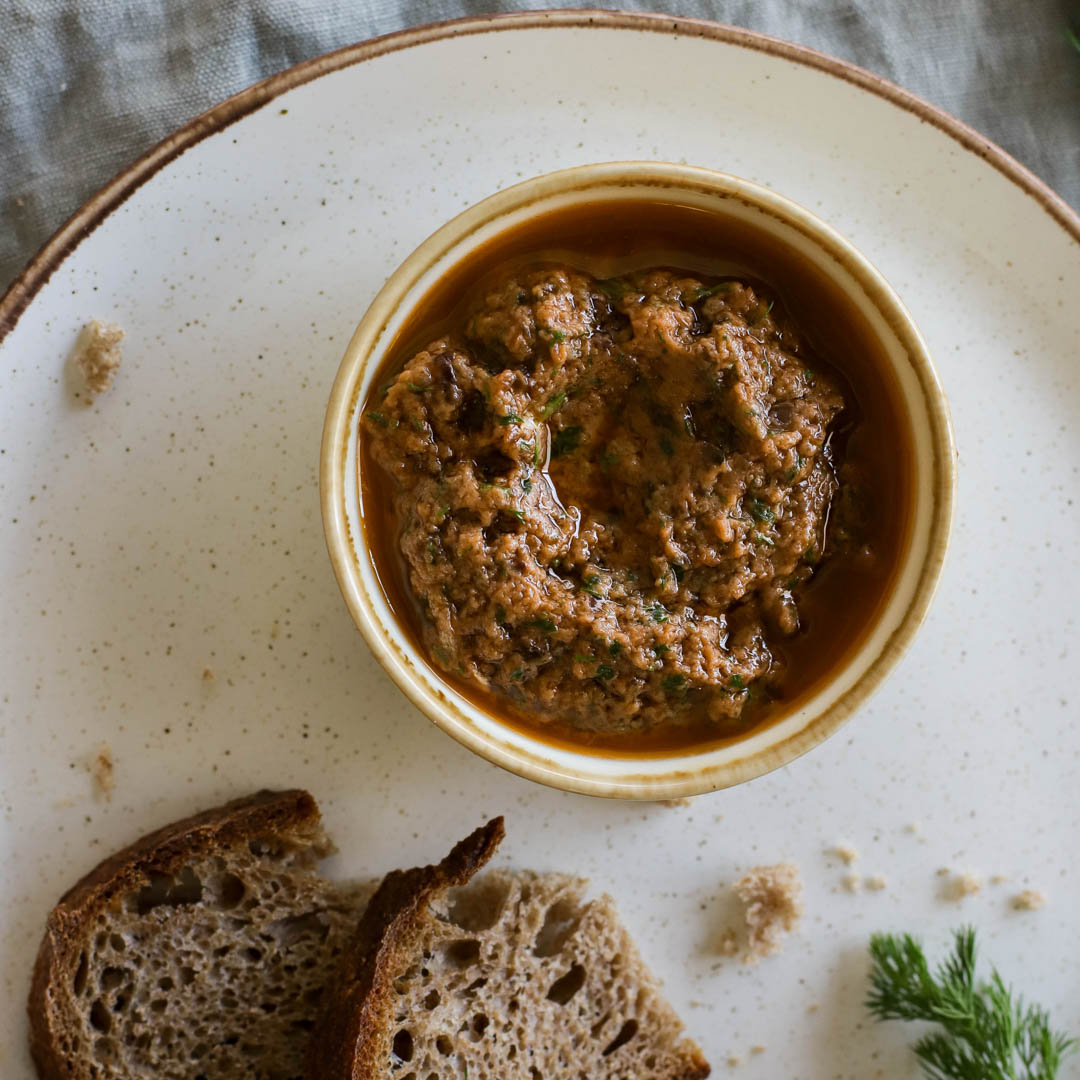 Brown dip in a white bowl on plate.