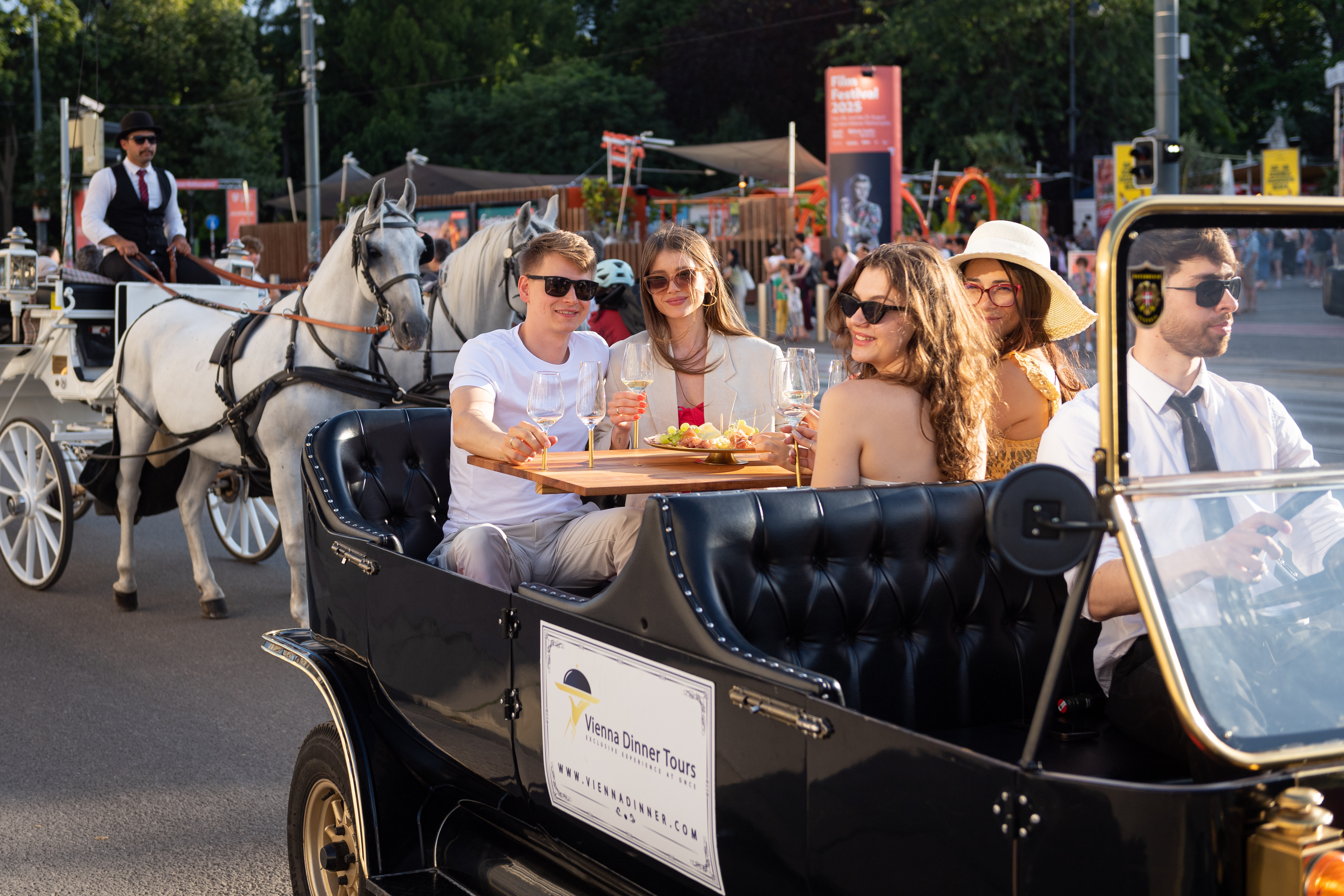 Personen speisen im Oldtimer mit naher Kutsche.