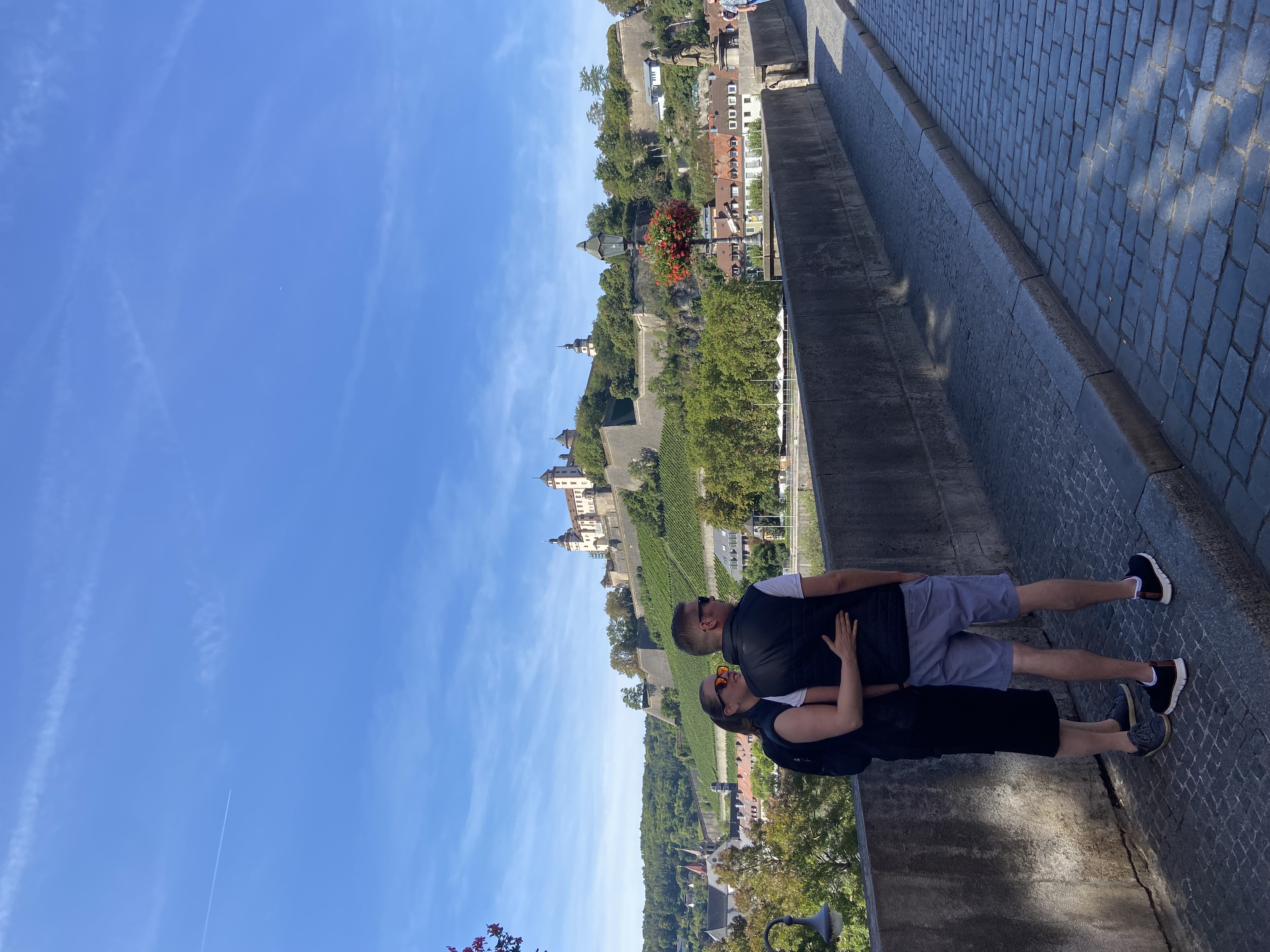 Couple admiring fortress from a bridge.