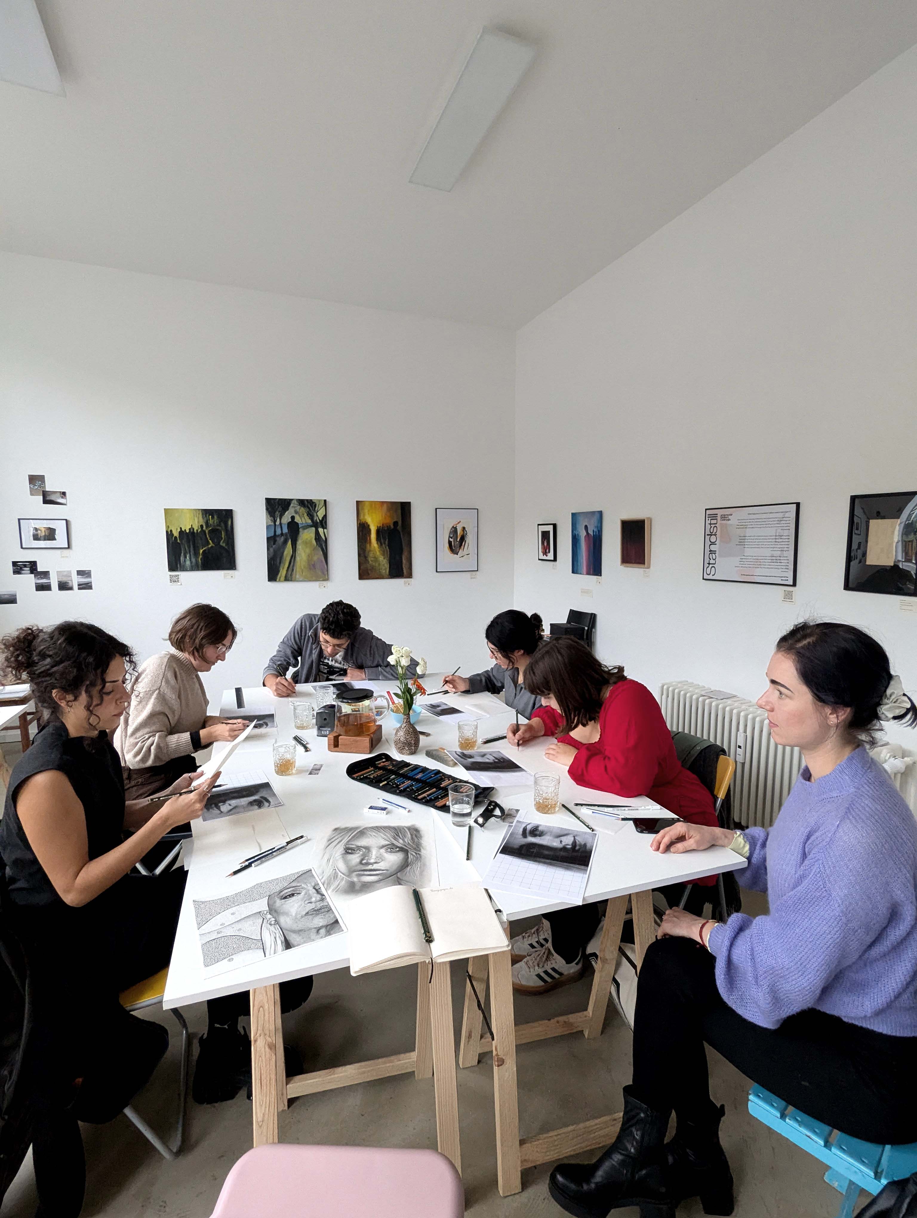 Group drawing portraits at a table.