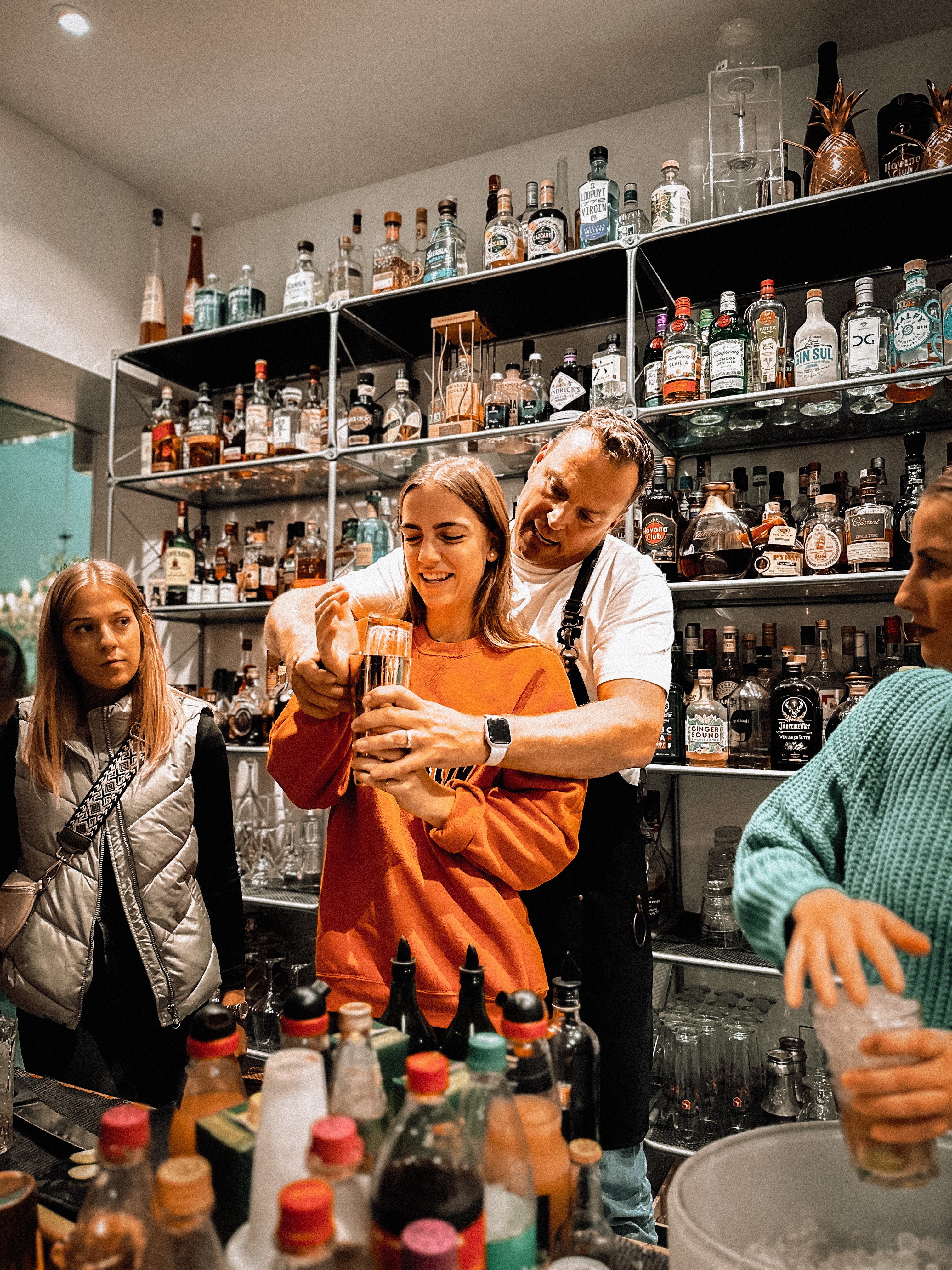Mann hilft Frau beim Mixen eines Getränks in Bar.