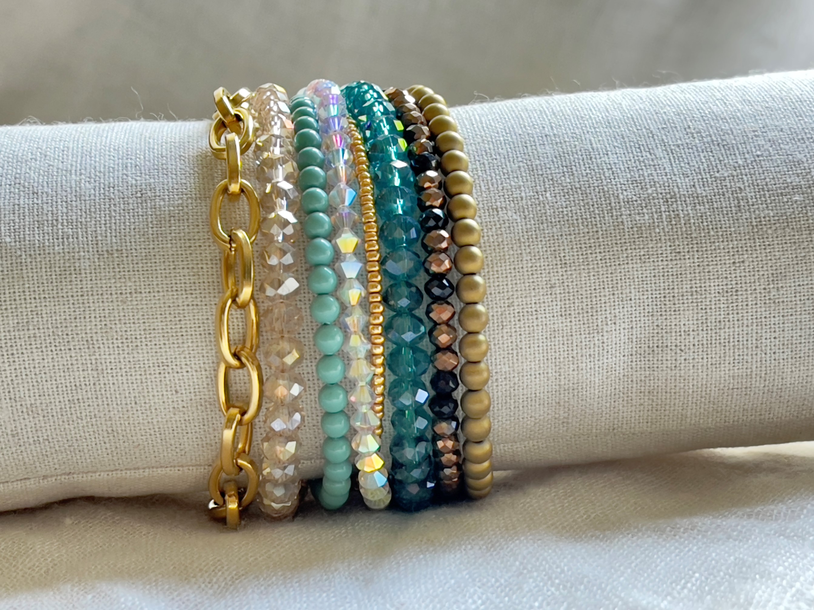 Bunte Perlen- und Kettenarmbänder auf Stoffdisplay.
