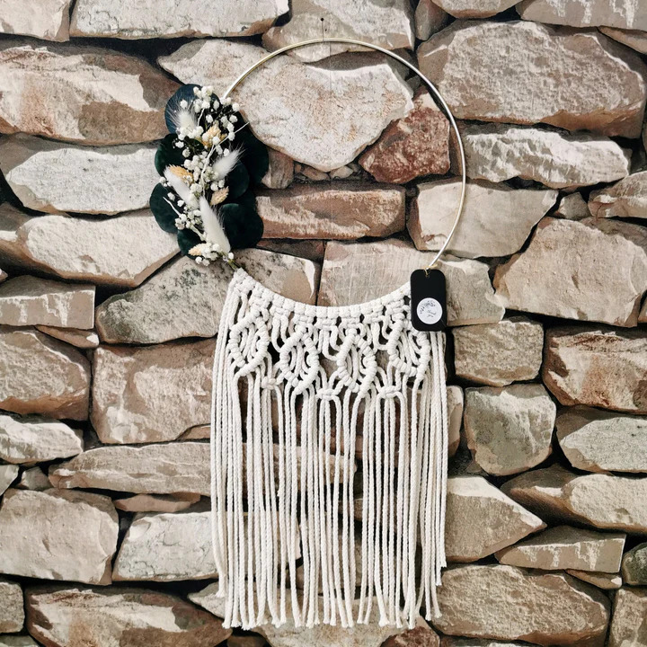 Decorative macrame wall hanger with dried plants.