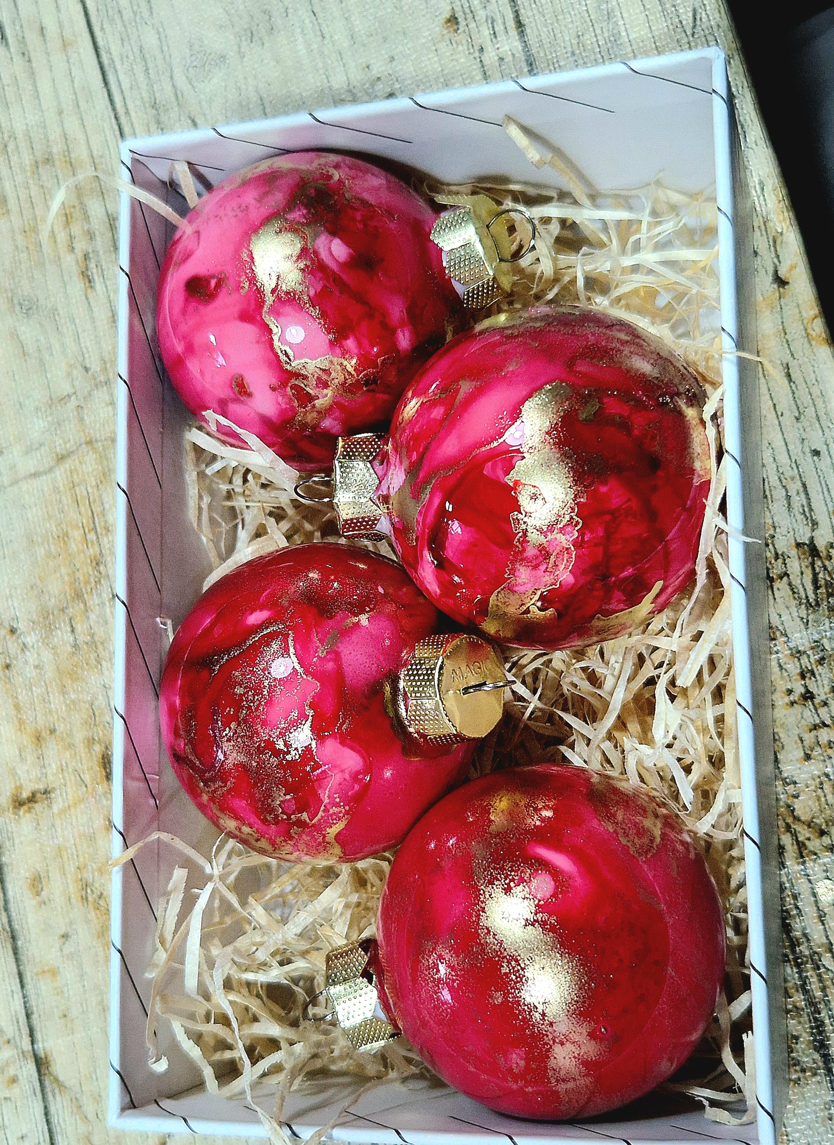 Rote und goldene Ornamente in einer Schachtel.