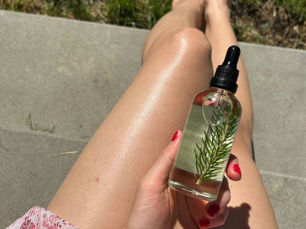 Hand holding bottle, person sitting outdoors.