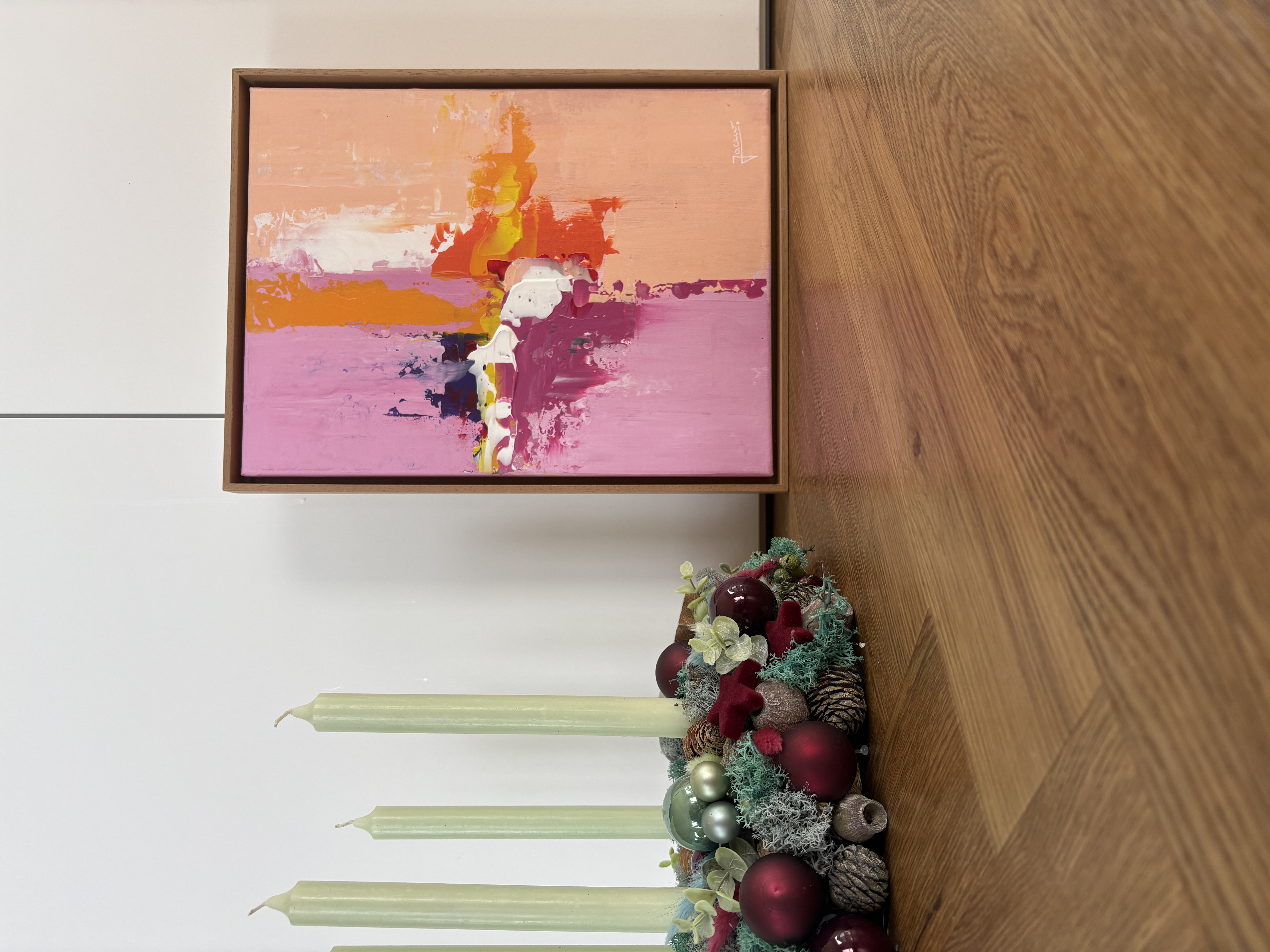 Abstract painting next to green candle wreath.
