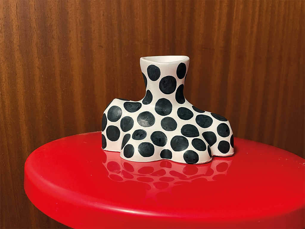Polka-Dot-Vase auf roter Fläche, Holz-Hintergrund.
