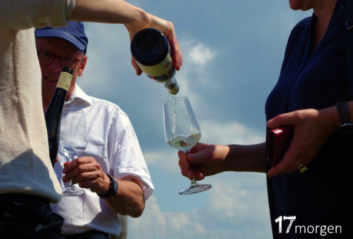 Glas wird mit Wein unter blauem Himmel gefüllt.