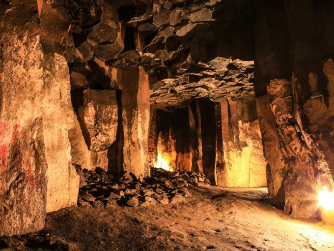 Dimly lit underground cave with stone pillars.