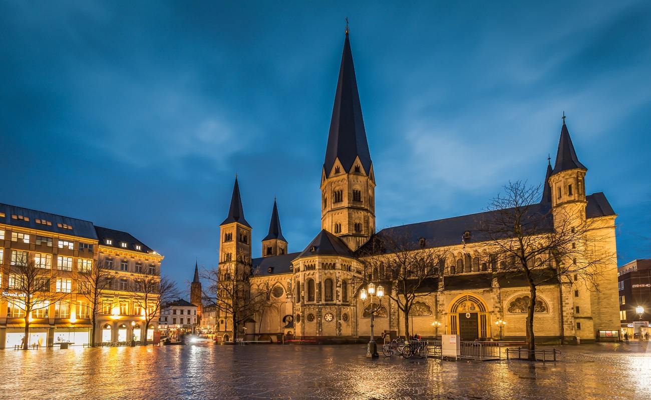 Kathedrale mit Türmen, umgeben von einer nächtlichen Stadtlandschaft.
