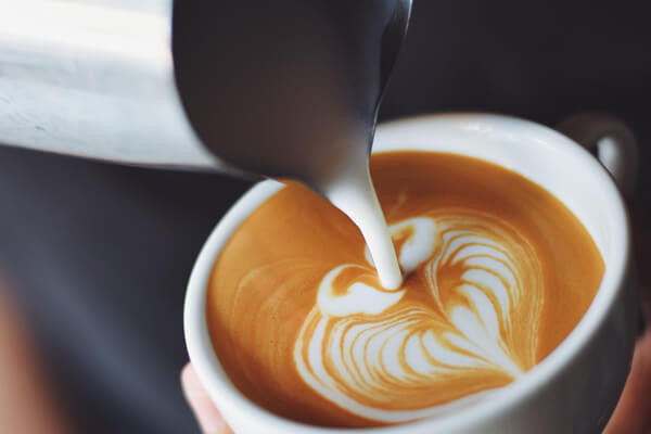Latte being poured with heart design.