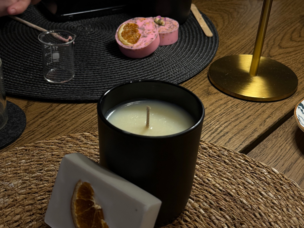 Black candle on wooden table with decor.