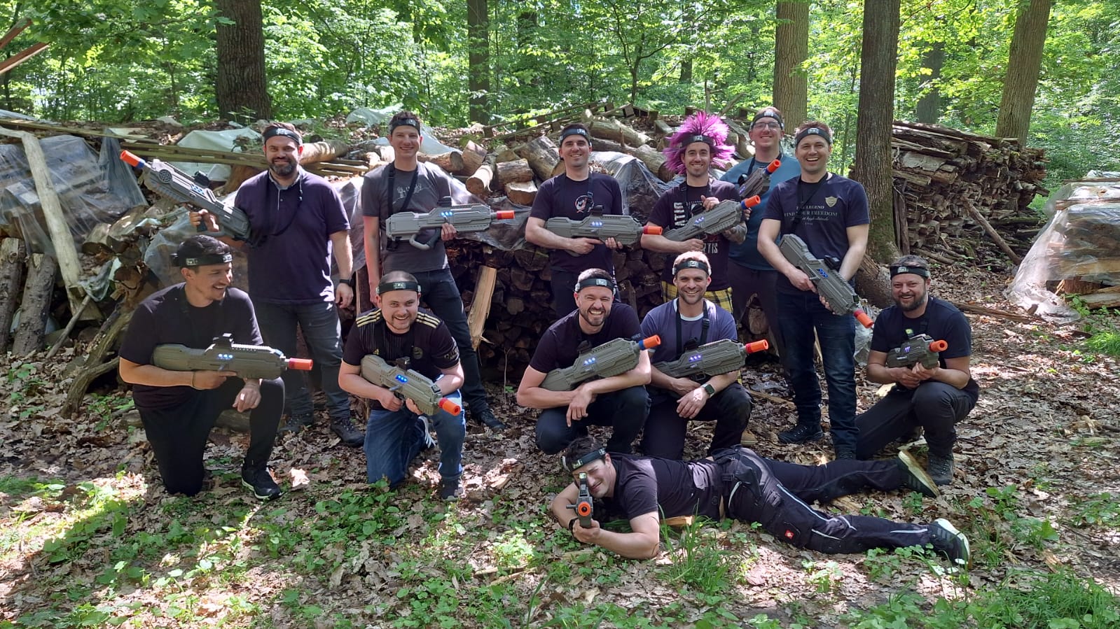 Group with toy guns in forest, smiling.