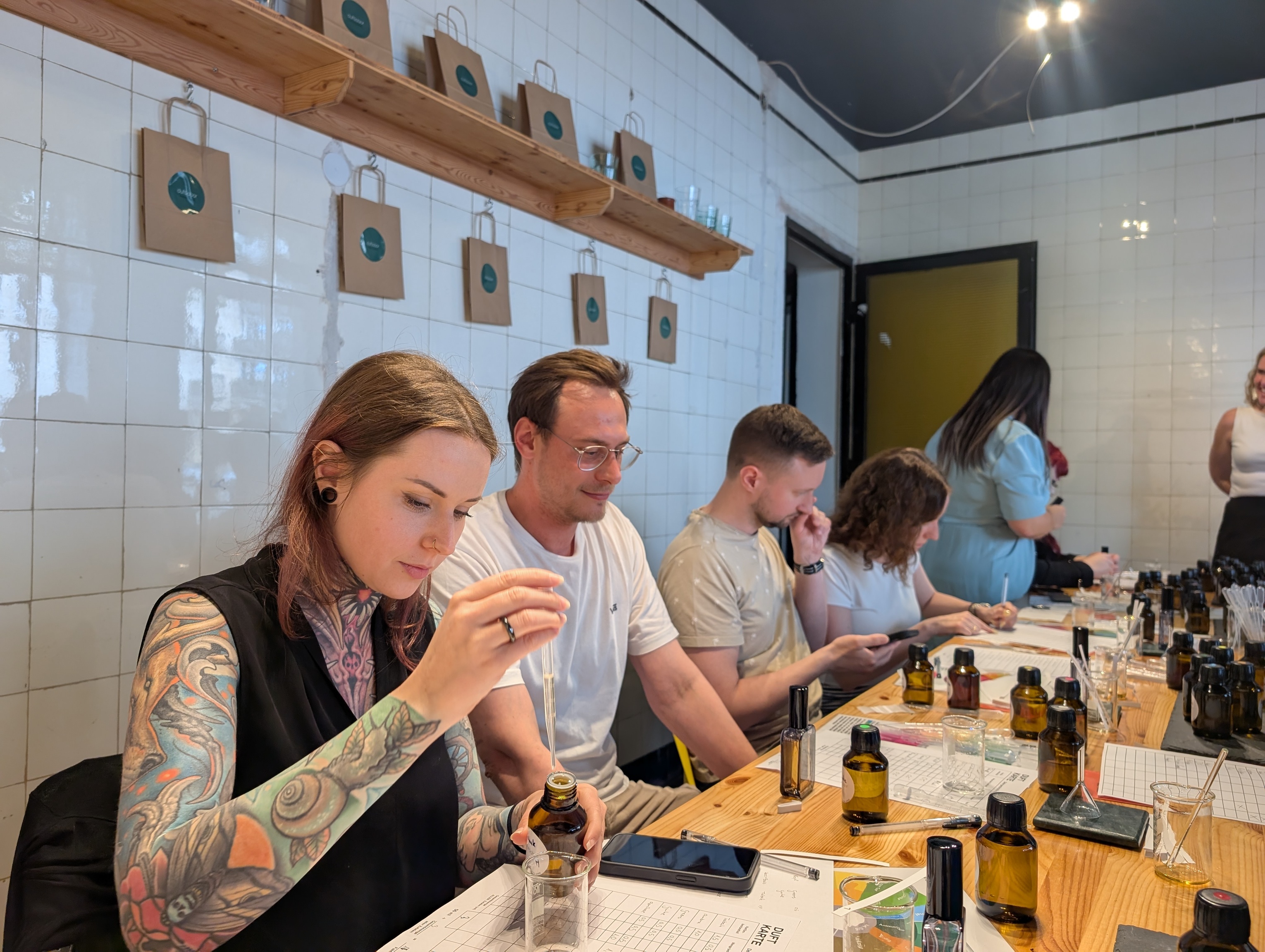People mixing fragrances at a workshop table.