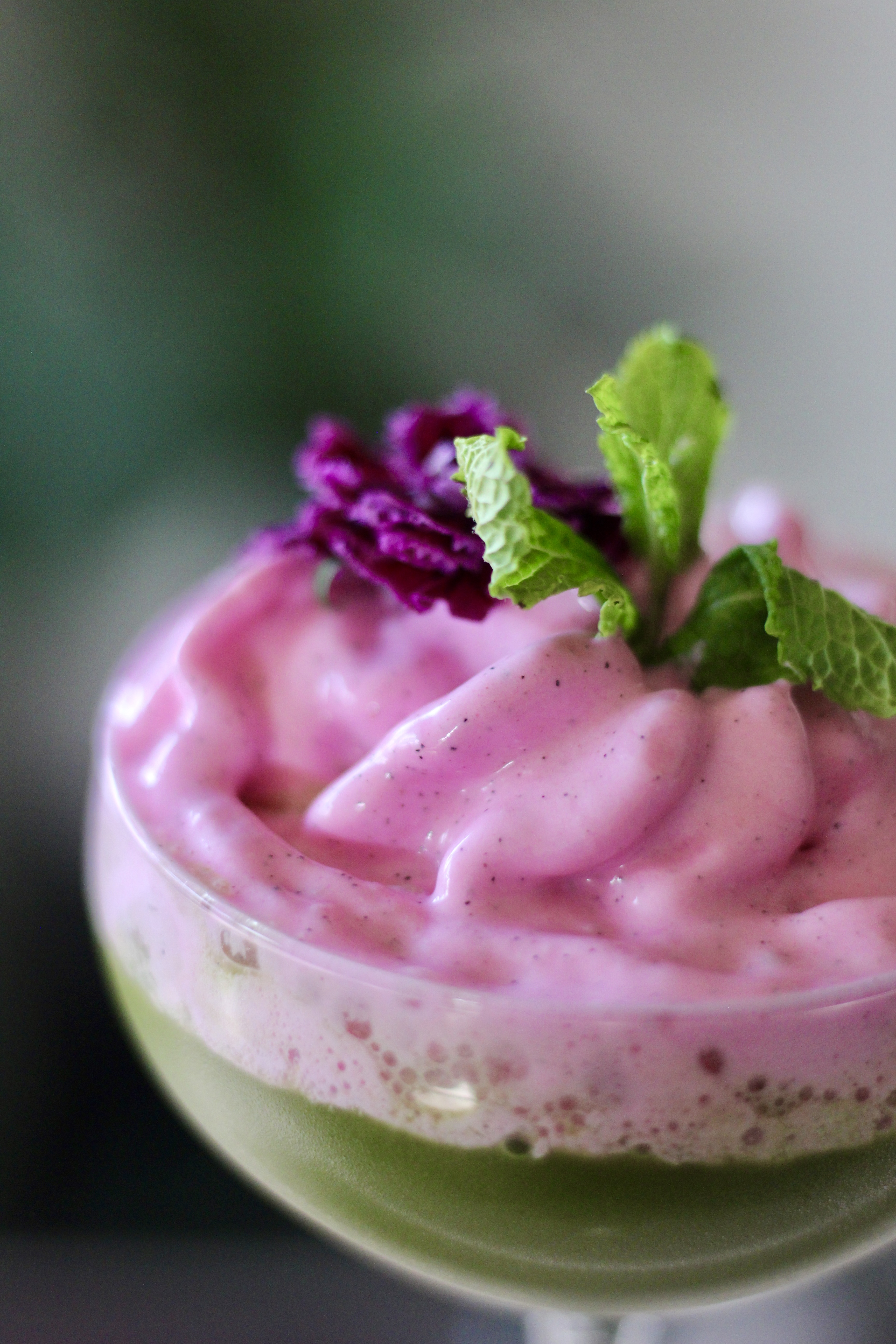 Rosa Mousse im Glas mit Minze garniert.