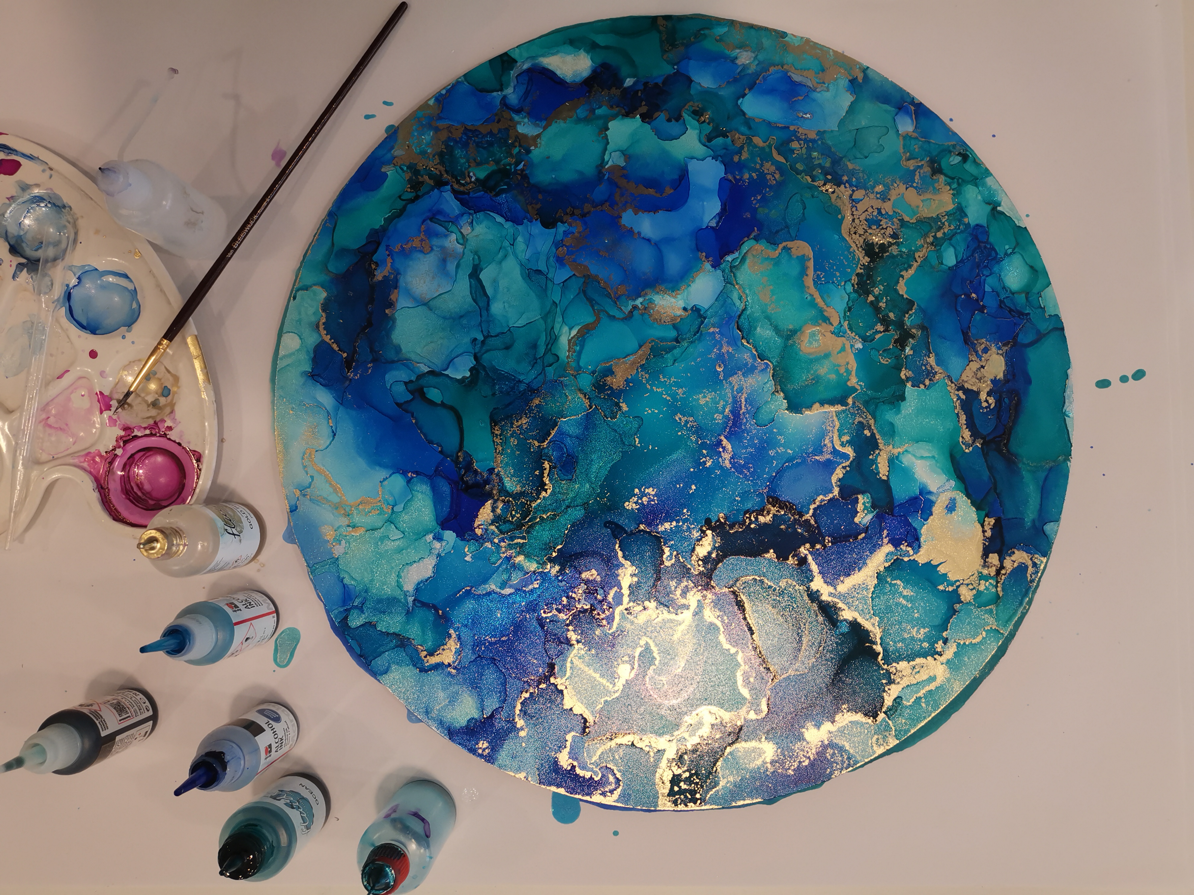 Runde Leinwand mit blauen Farben und goldenen Akzenten.