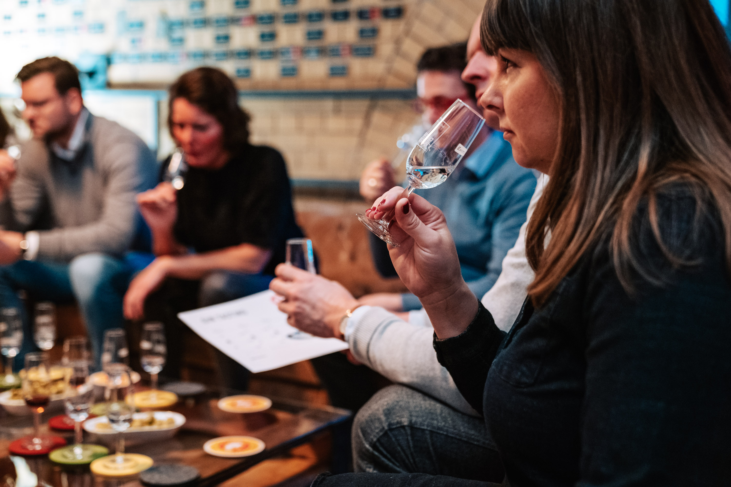 Menschen verkosten Wein in gemütlicher Umgebung.