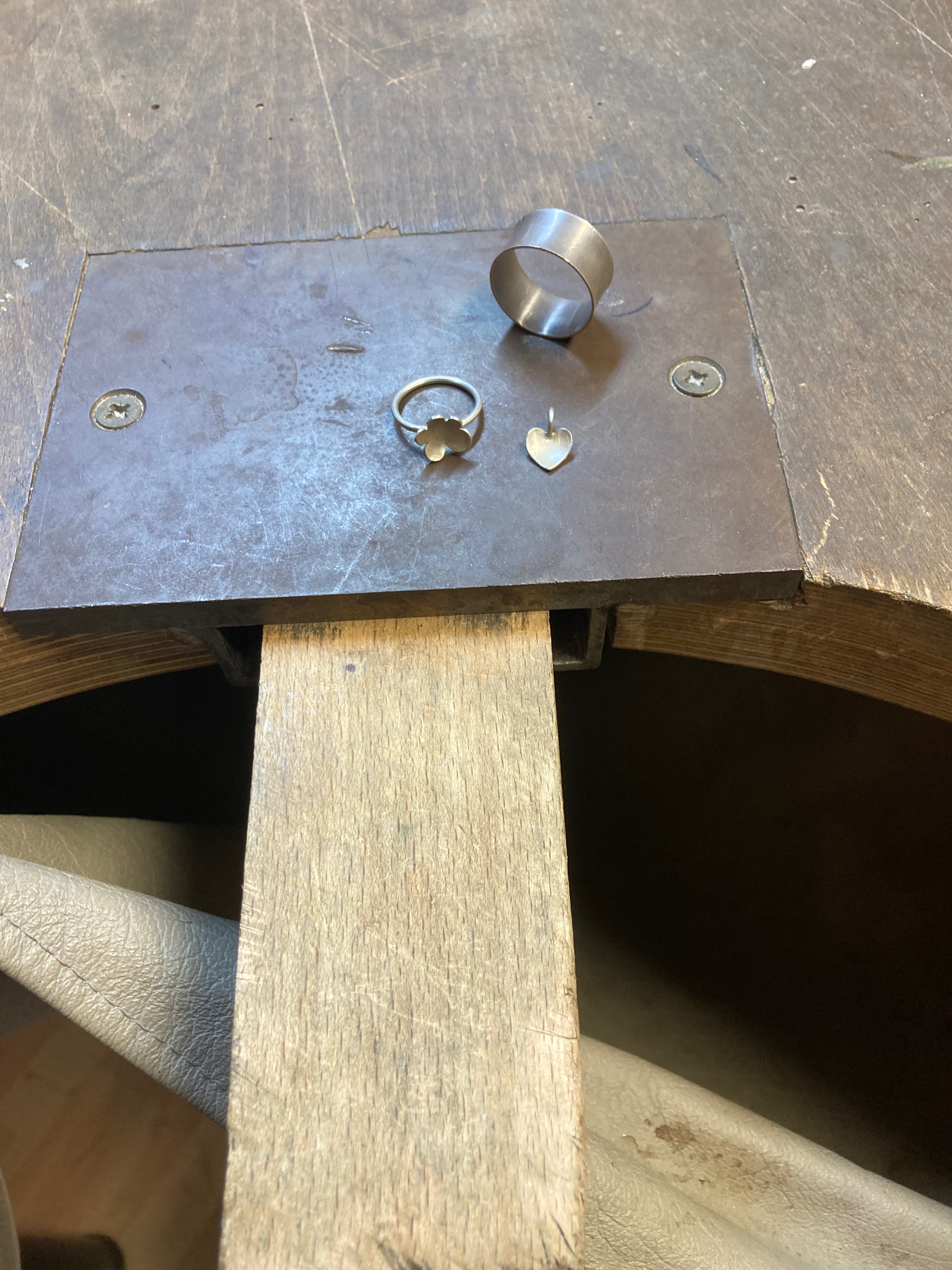 Ringe und Anhänger auf einem Werktisch.