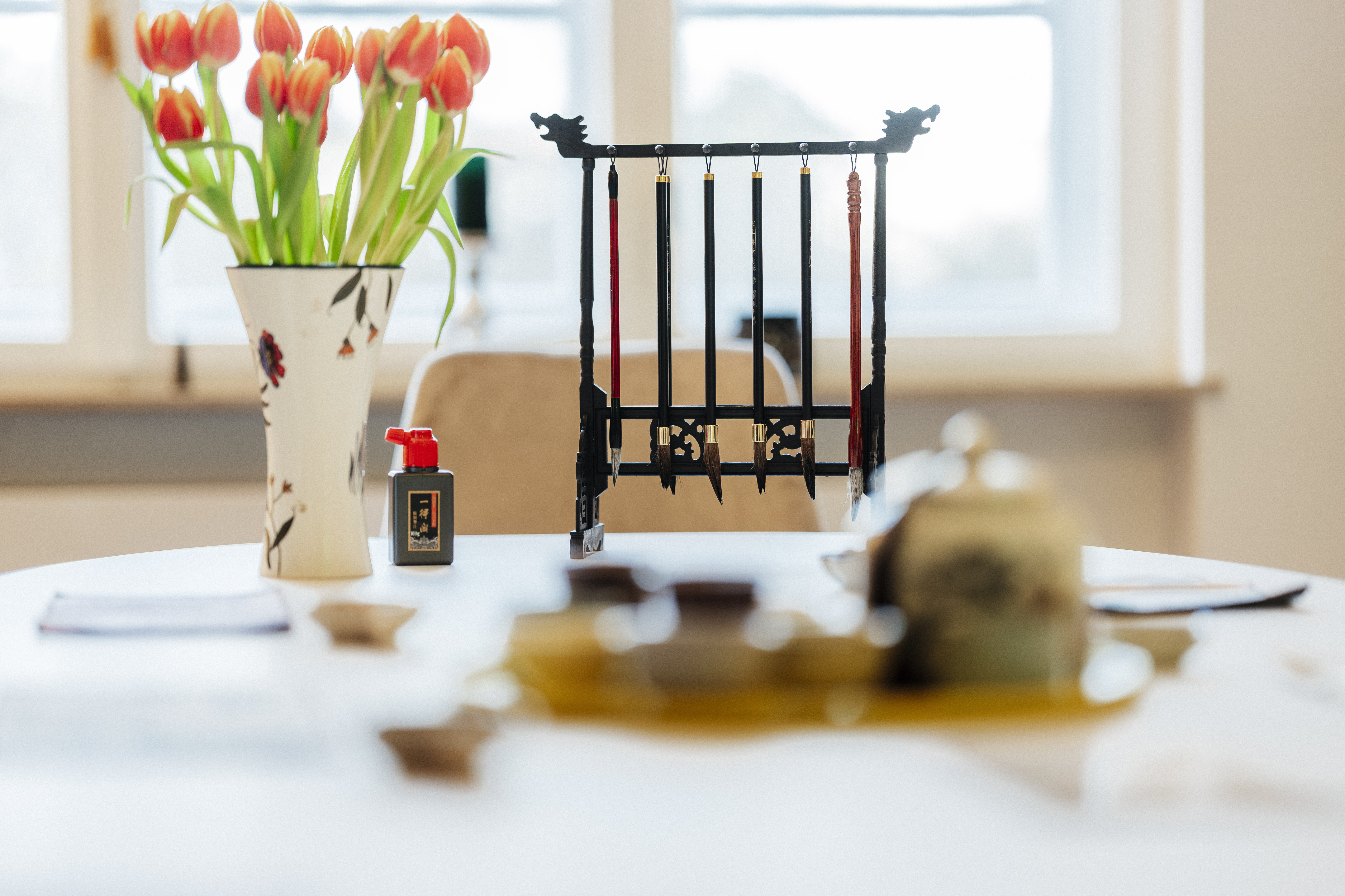 Vase with tulips on table by window.