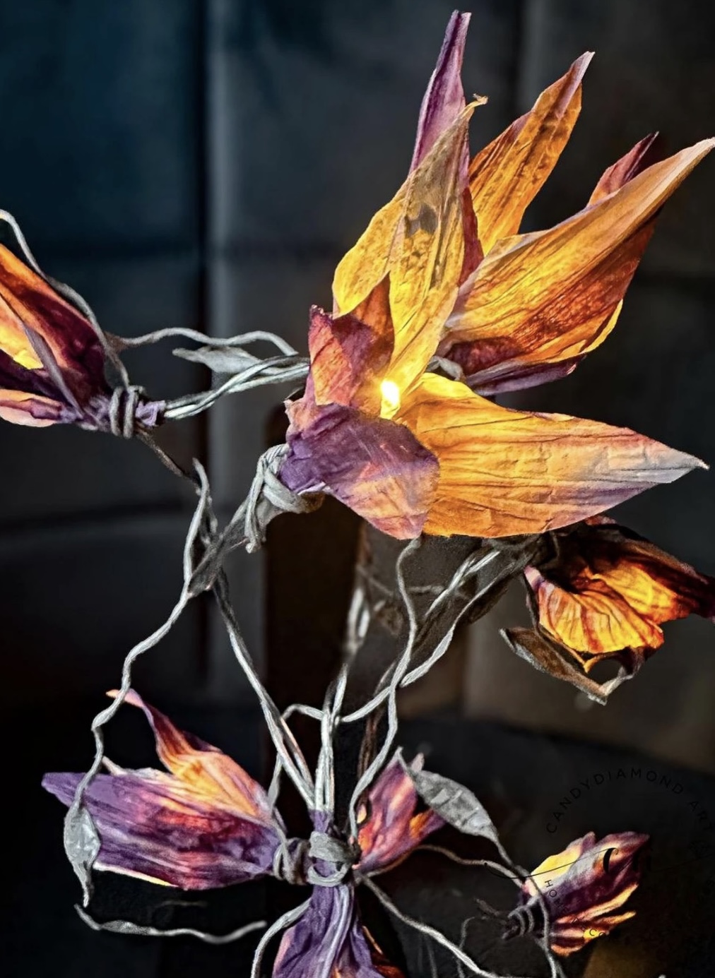 Illuminated decorative flower, glowing warmly in darkness.