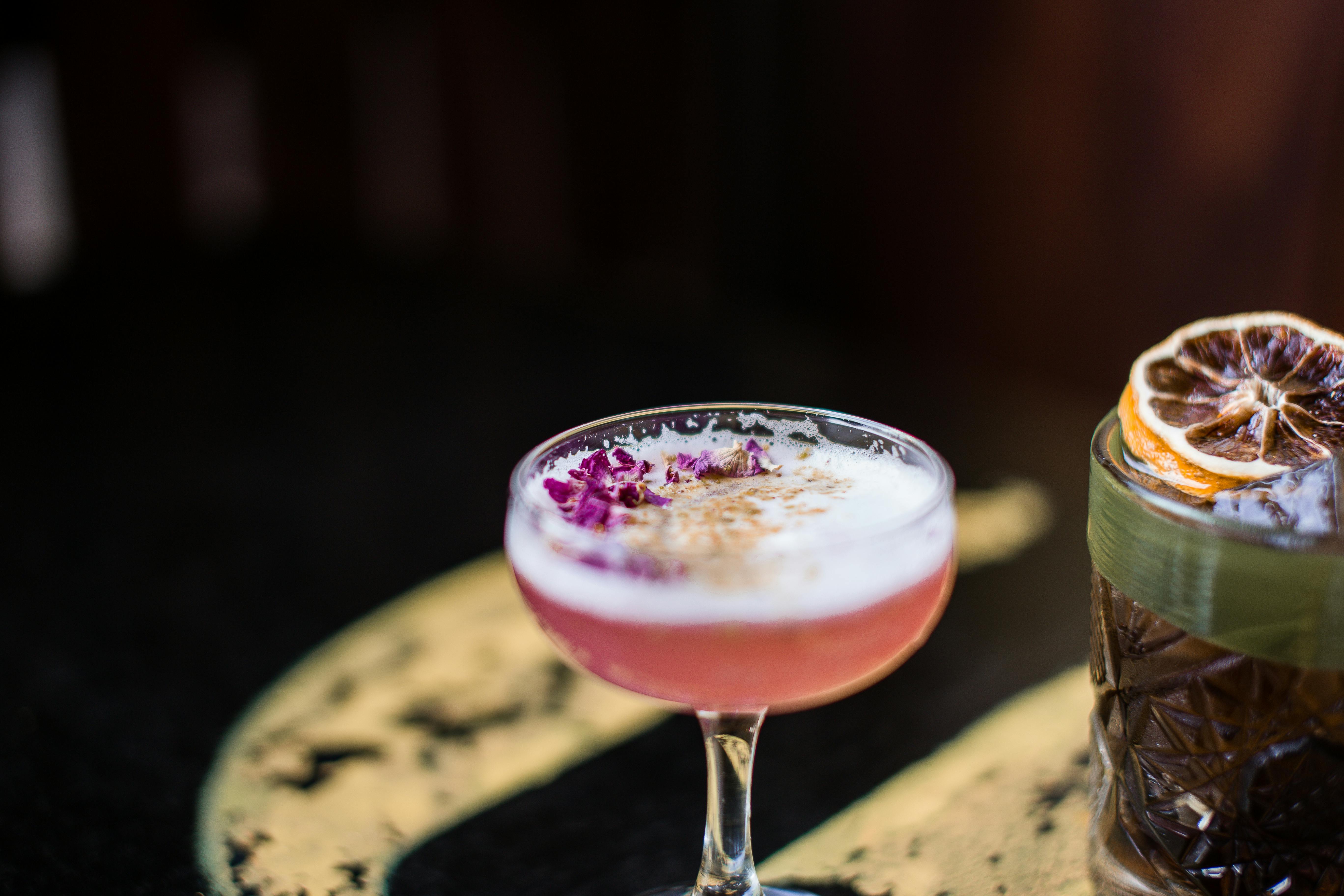 Bunte Cocktailgläser auf dunklem Tisch.