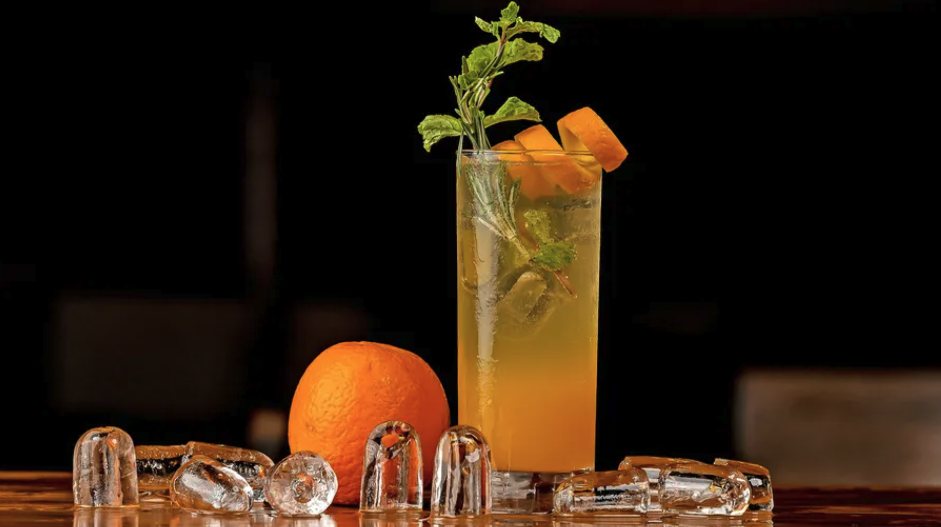 Orangencocktail auf Tisch mit Eiswürfeln.