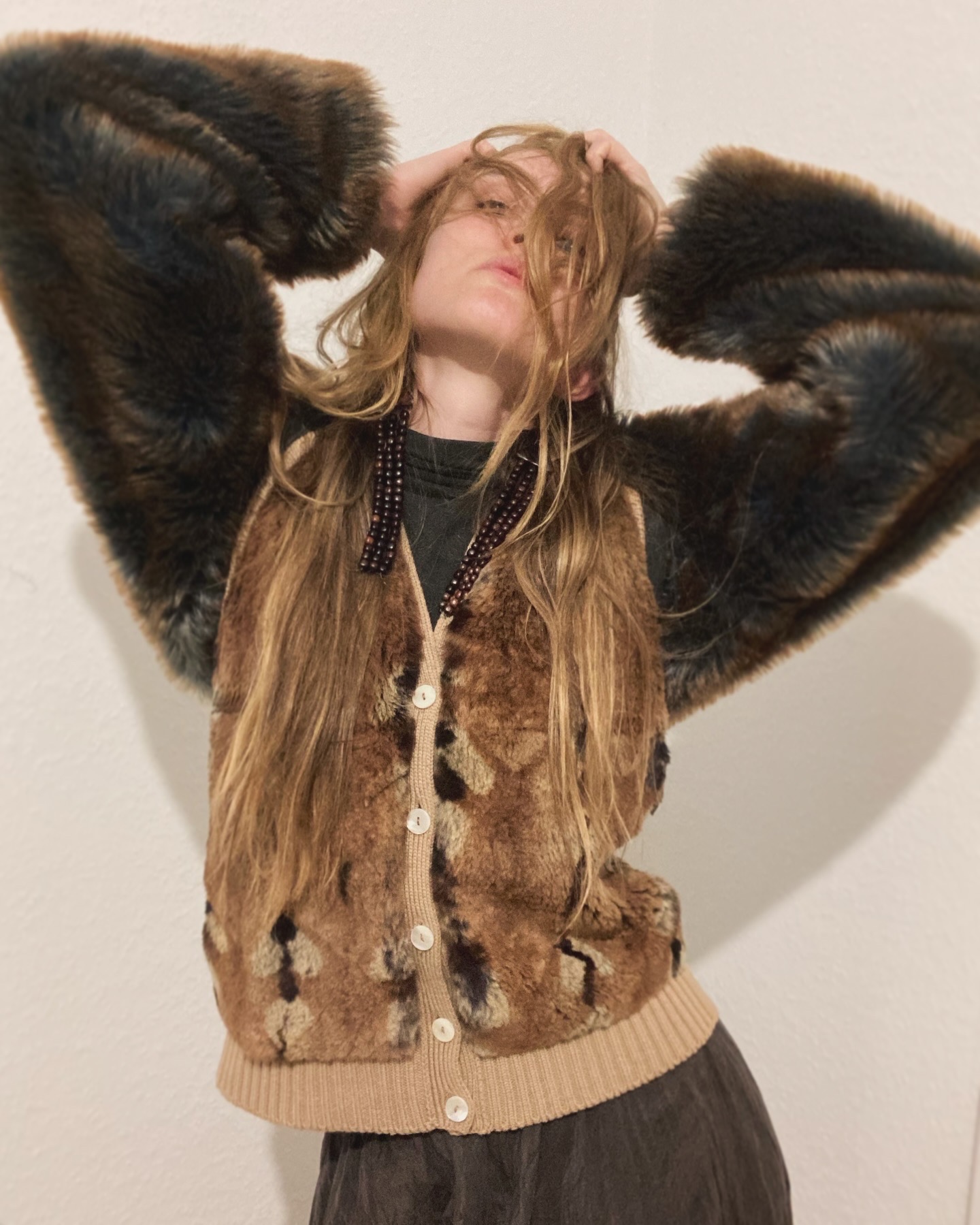 Person wearing fur coat poses indoors.
