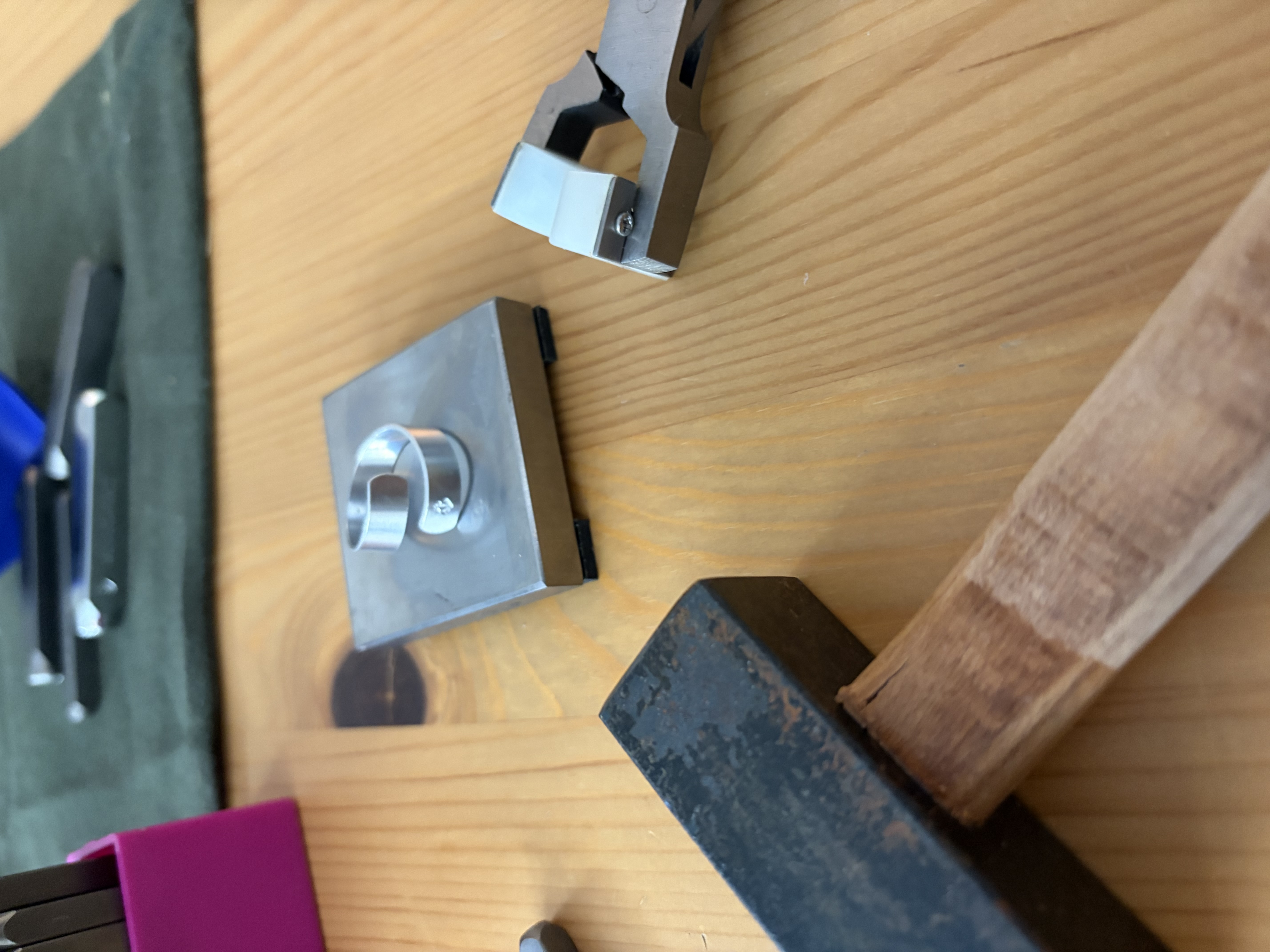 Metallwerkzeuge und Stück auf Holztisch.
