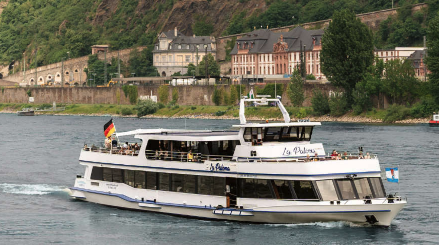 Touristenboot fährt auf einem Fluss, malerische Kulisse.
