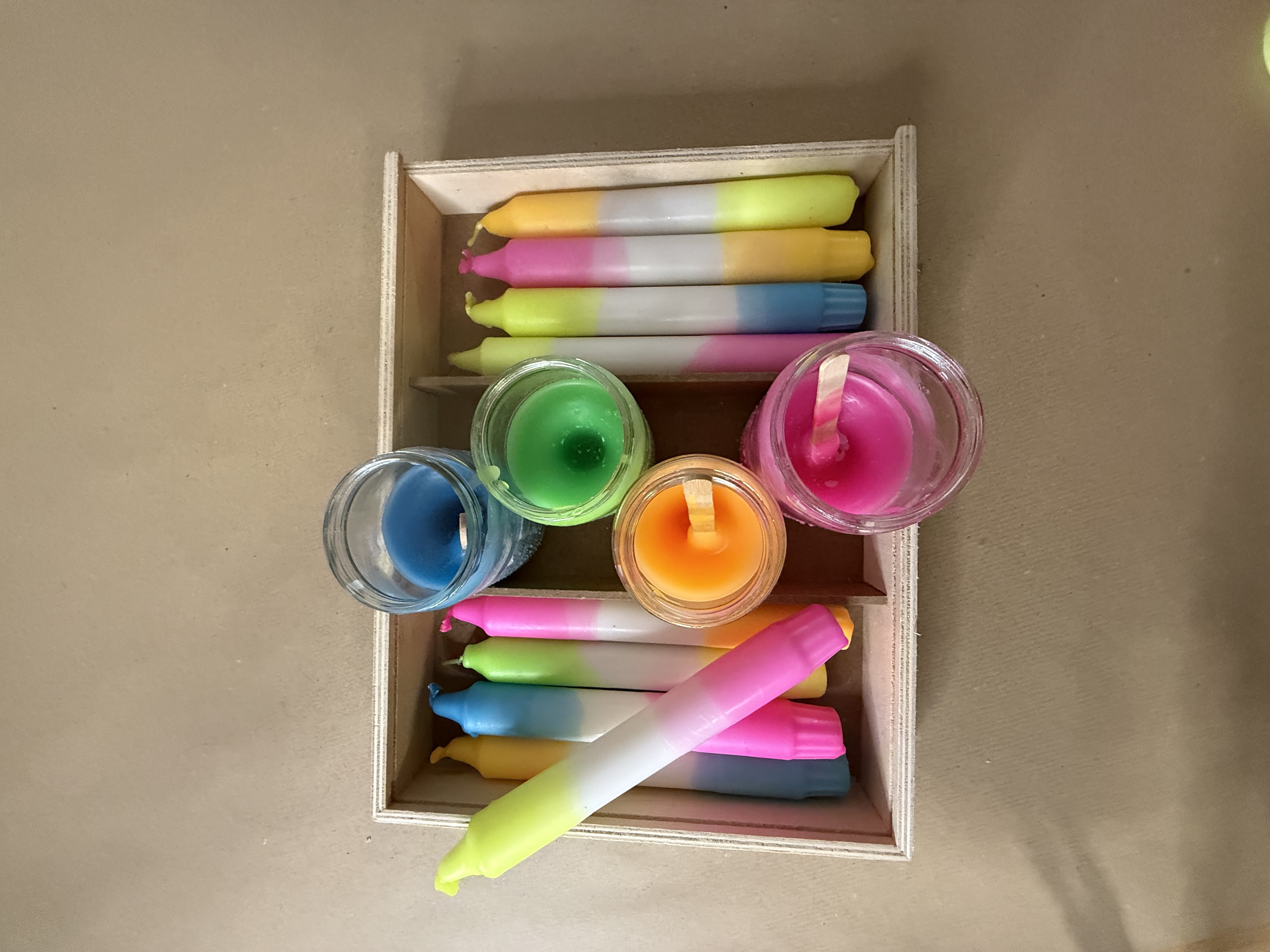 Colorful candles in a wooden box.