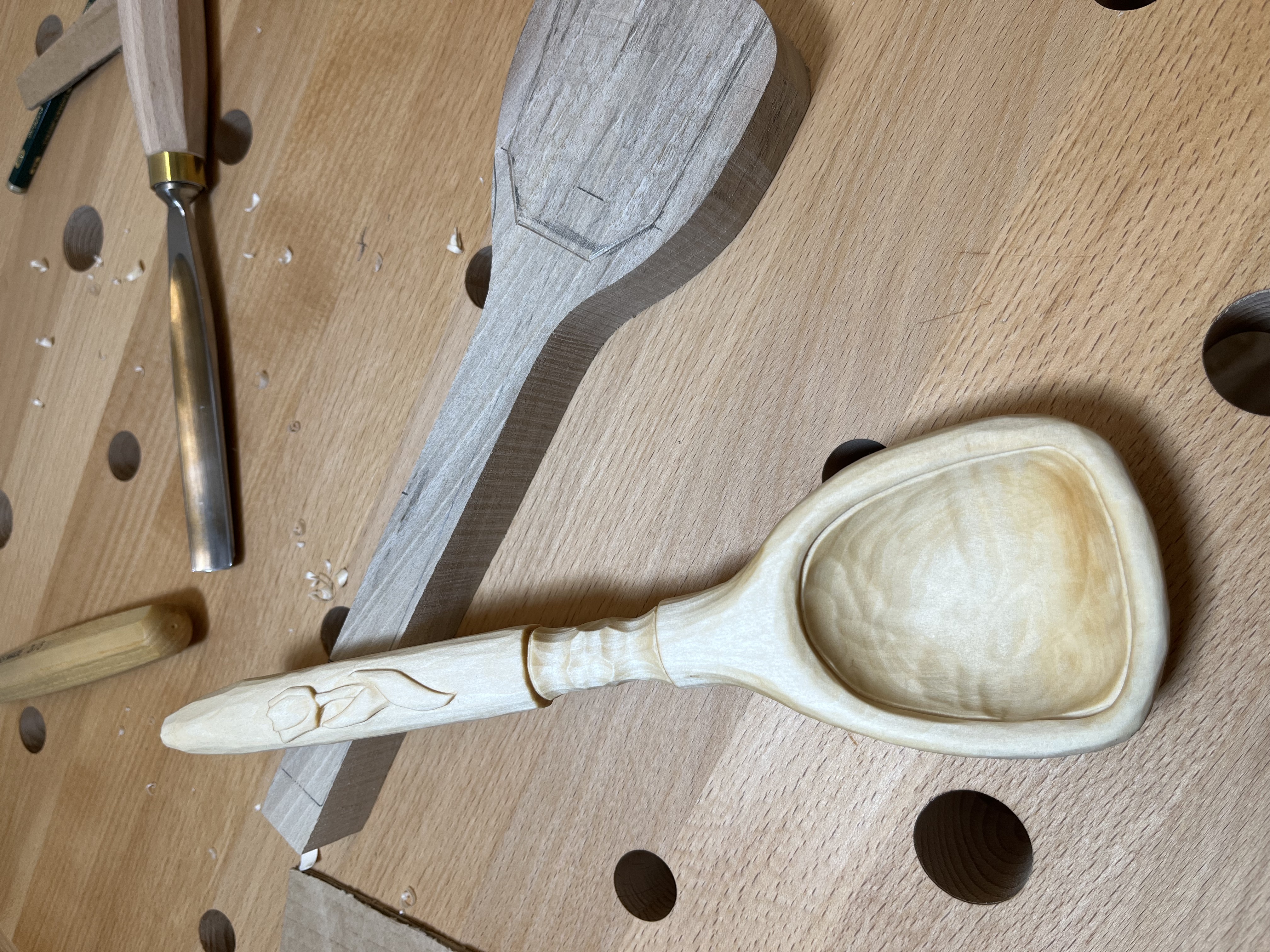 Geschnitzter Holzlöffel mit Tulpendesign.