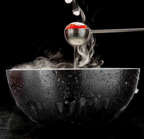 A spoon lifts a steaming tomato out of a bowl.