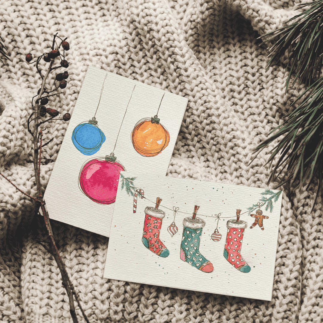 Weihnachtskarten auf gestrickter Decke mit Kiefernzweig.