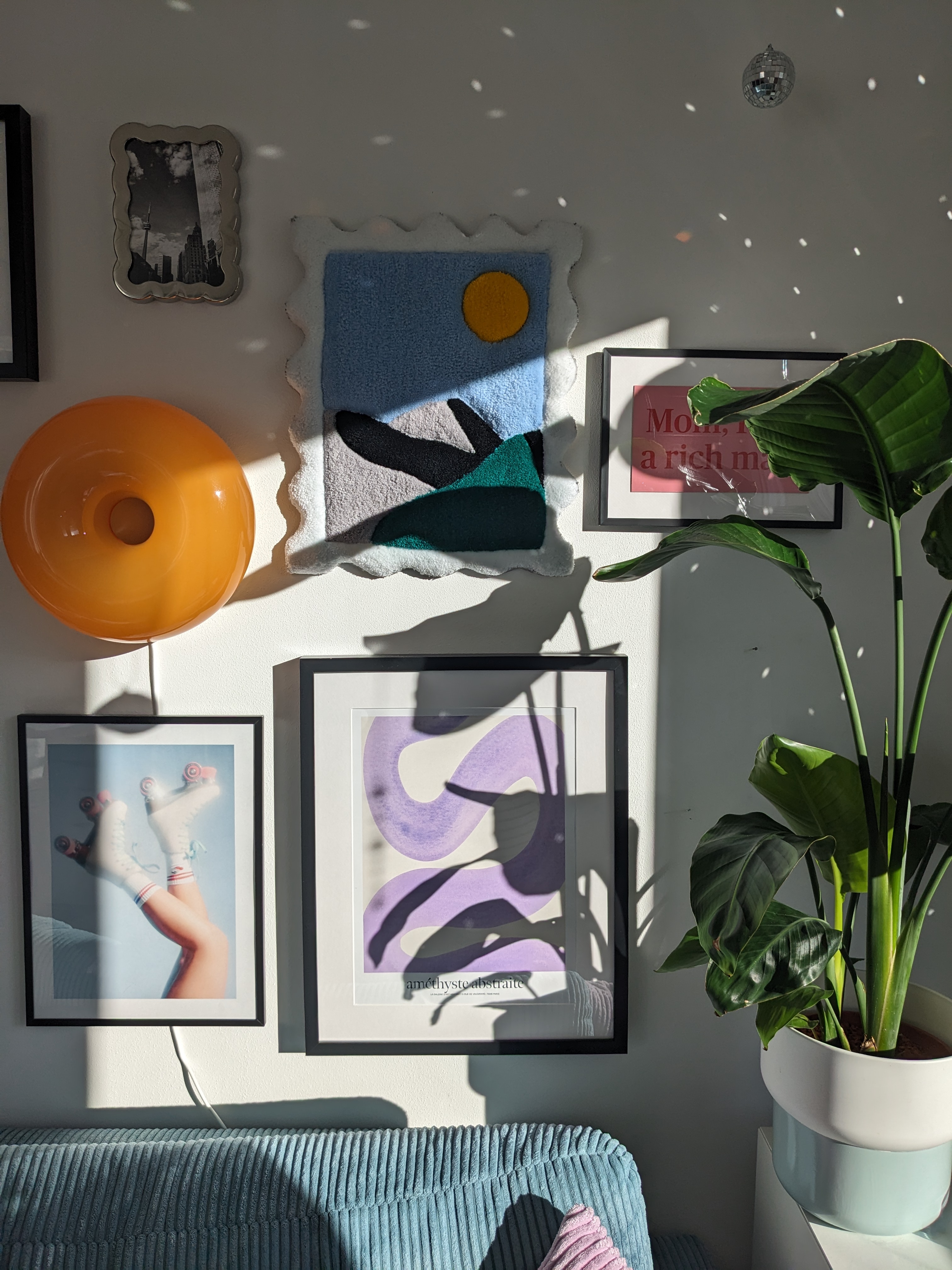 Wandkunst und Pflanze im Sonnenlicht.