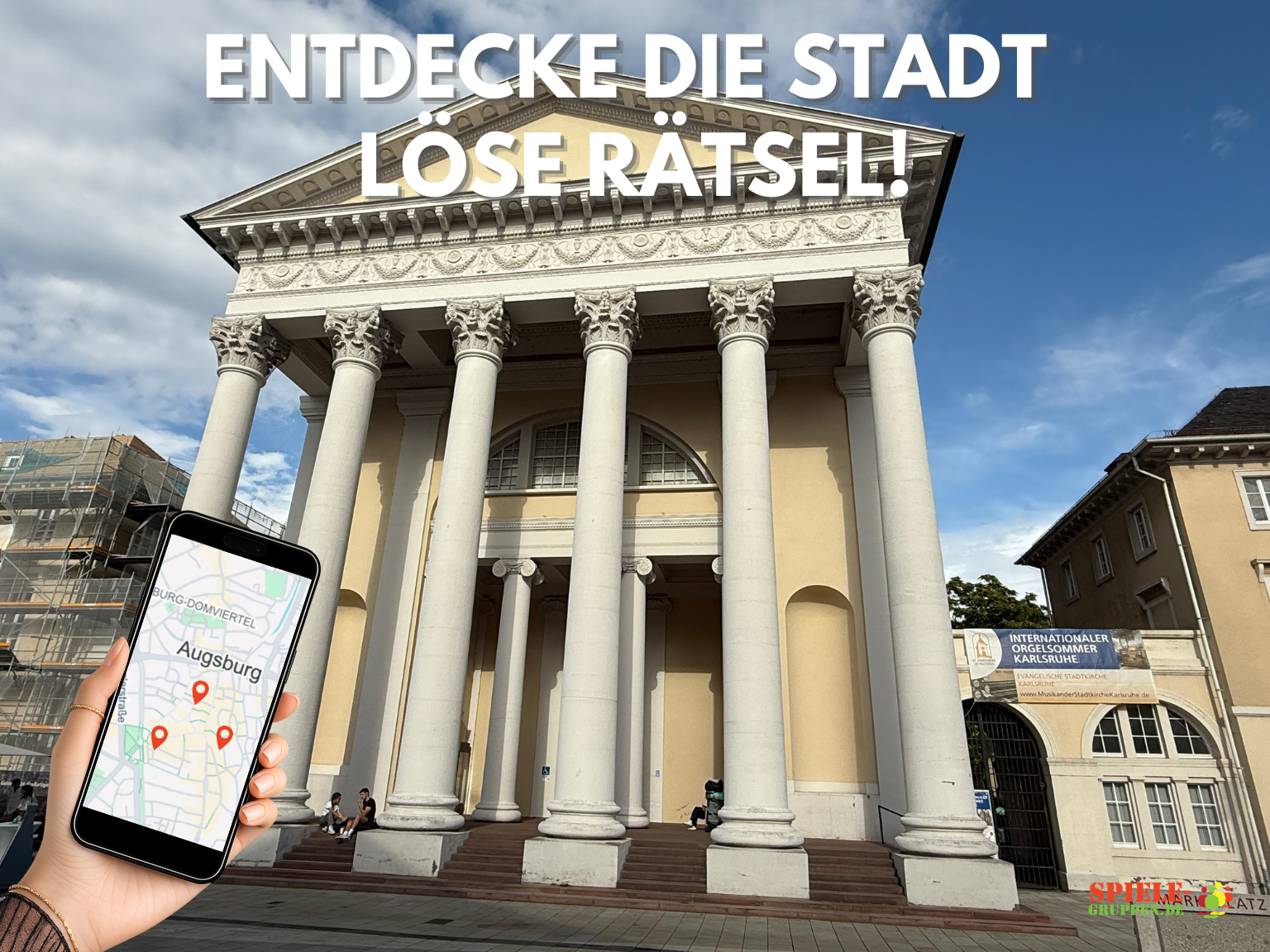 Hand hält Handy mit Augsburg-Karte, Gebäude im Hintergrund.