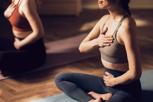 Two women practicing yoga in a studio.