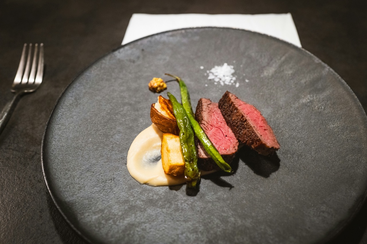 Gourmet-Steakgericht mit Gemüse auf einem Teller.