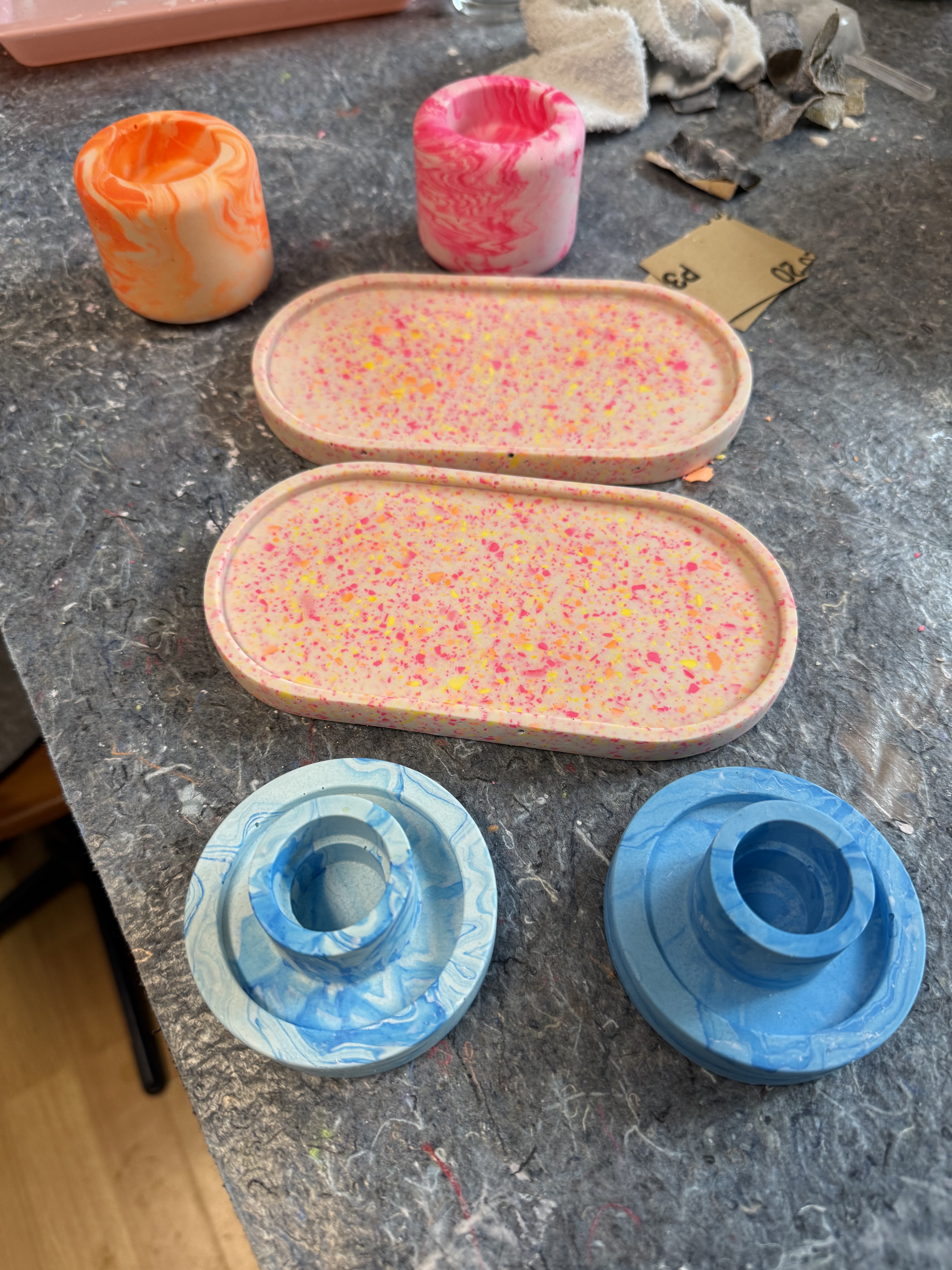 Two speckled trays on a textured surface.