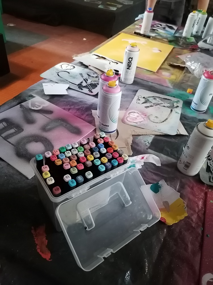 Spray paint cans and stencils on table.