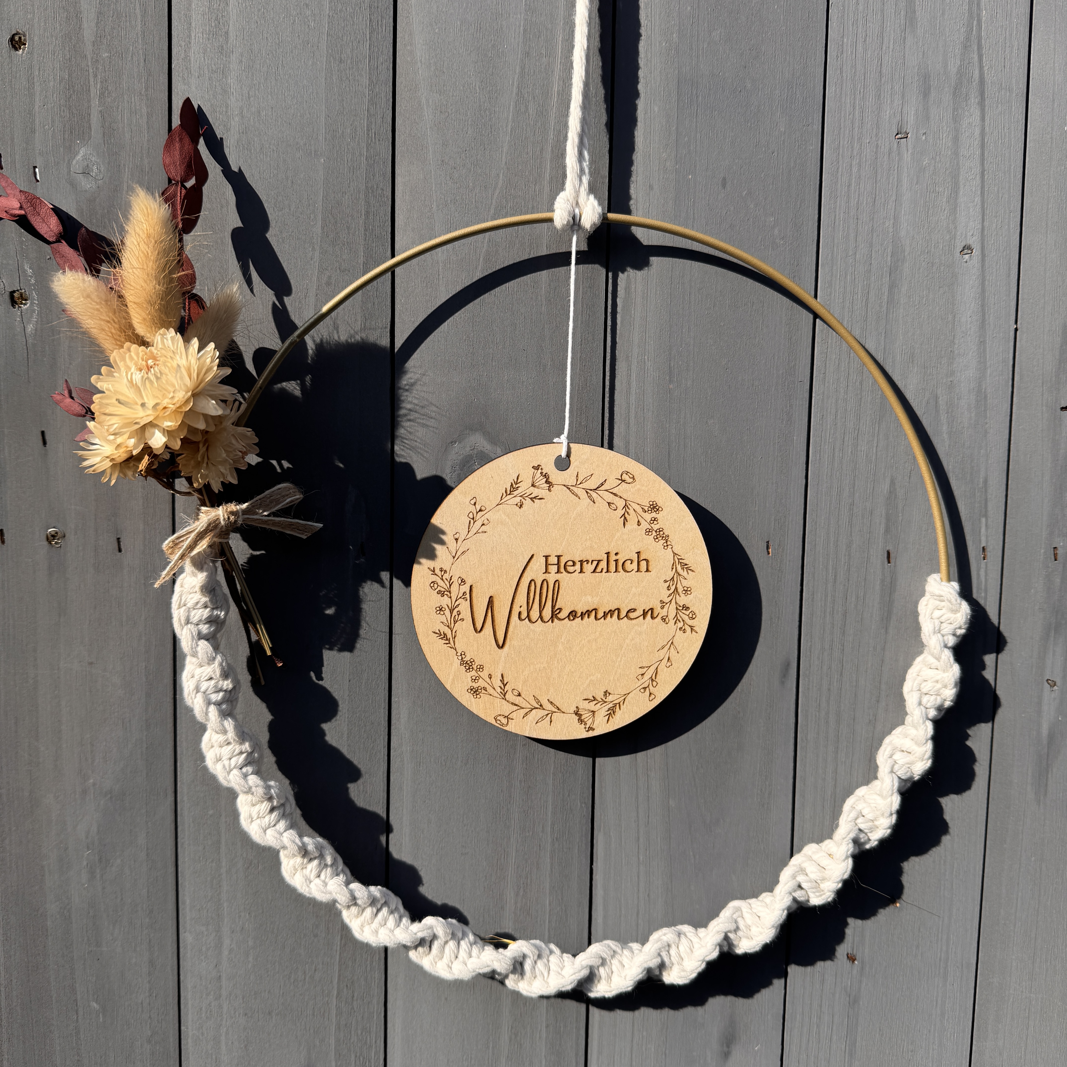 Decorative wreath with welcome sign on wood.