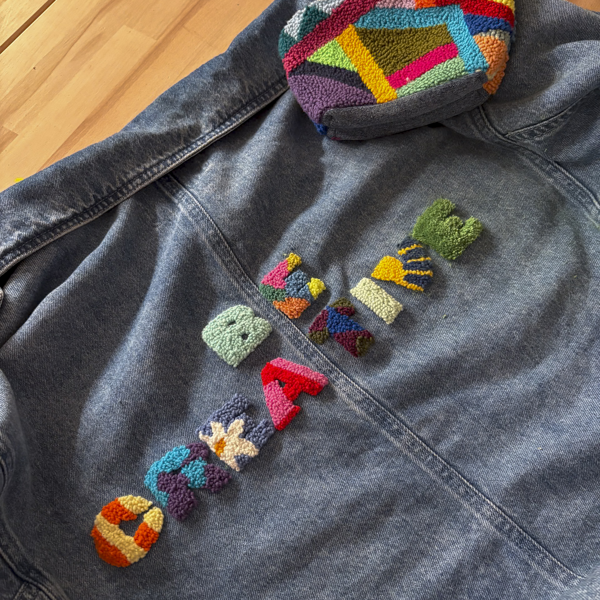 Denim jacket with colorful embroidery design.