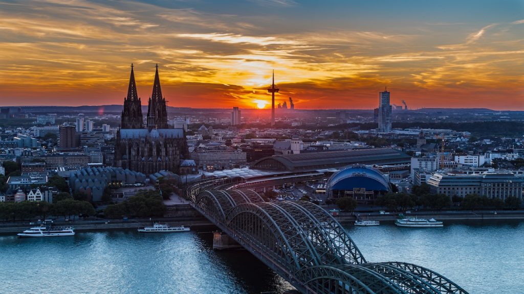 Kathedrale und Brücke über Fluss bei Sonnenuntergang.