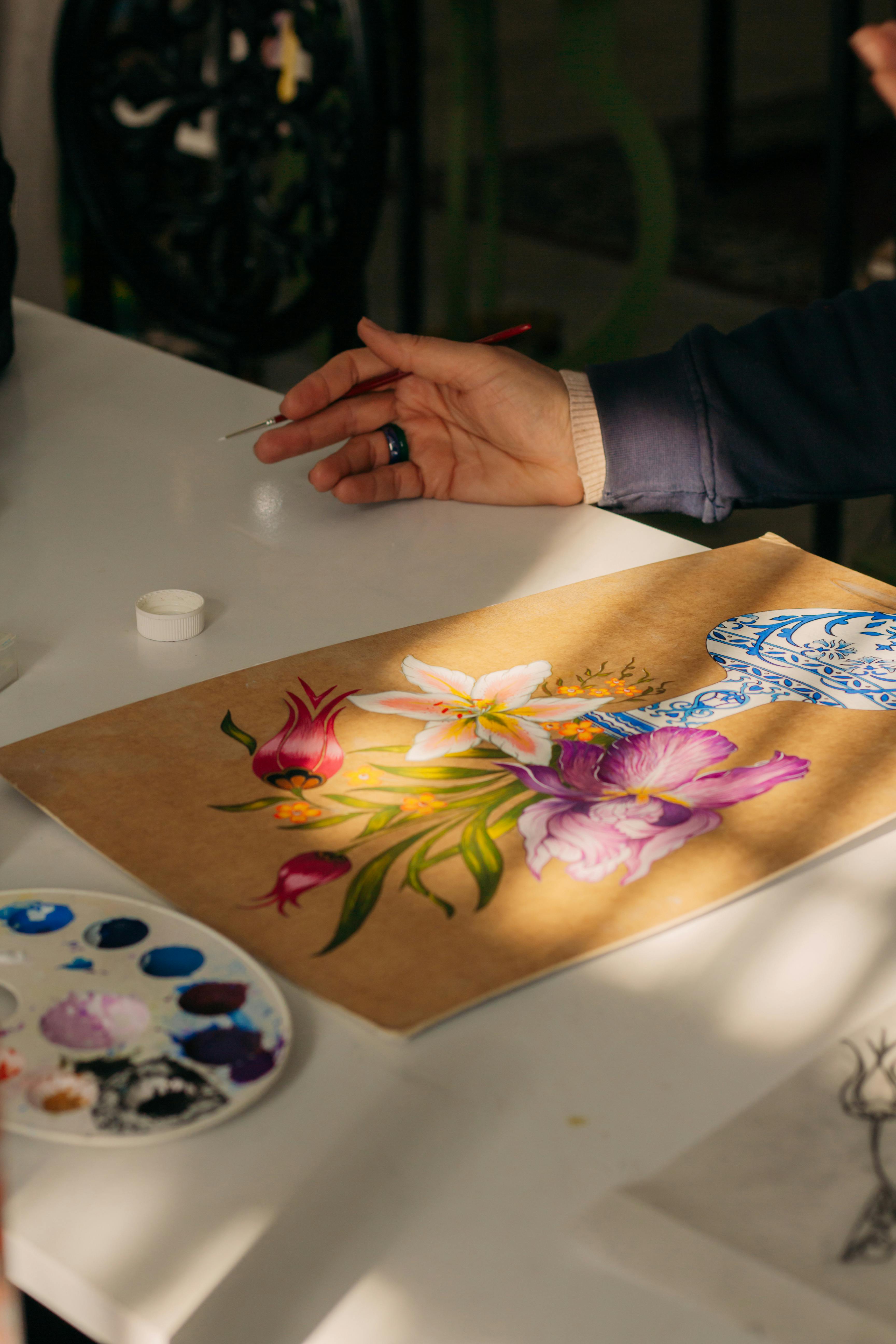 Hand painting floral design on brown paper.