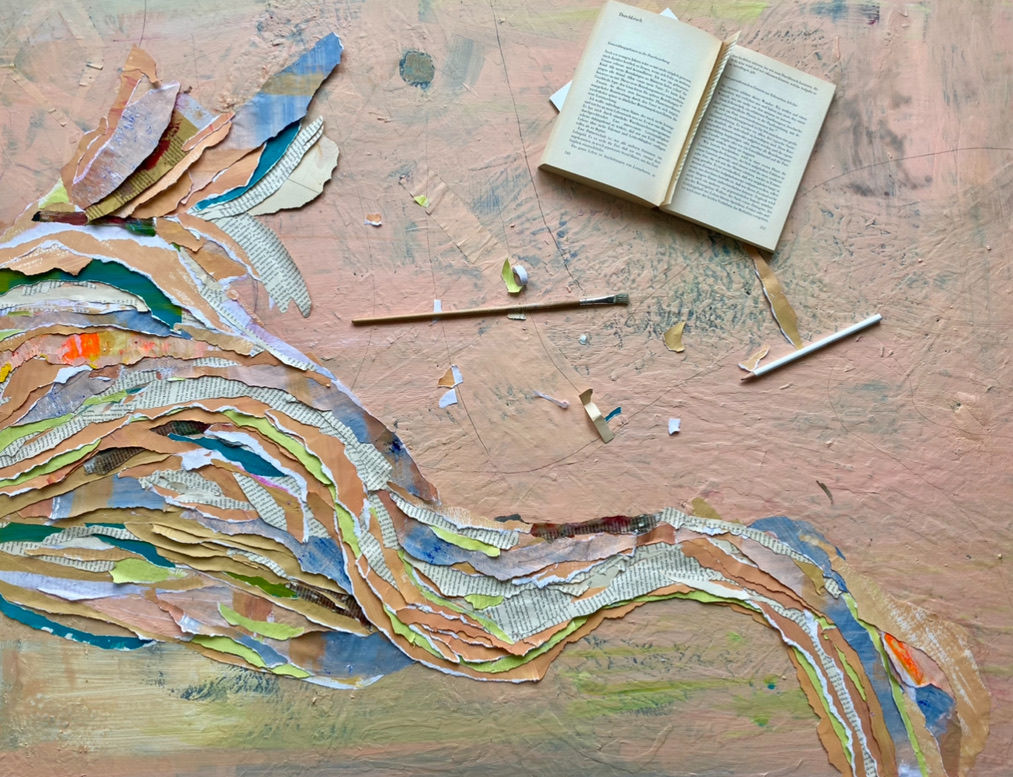 Buntes Papier-Collage auf Tisch mit offenem Buch.
